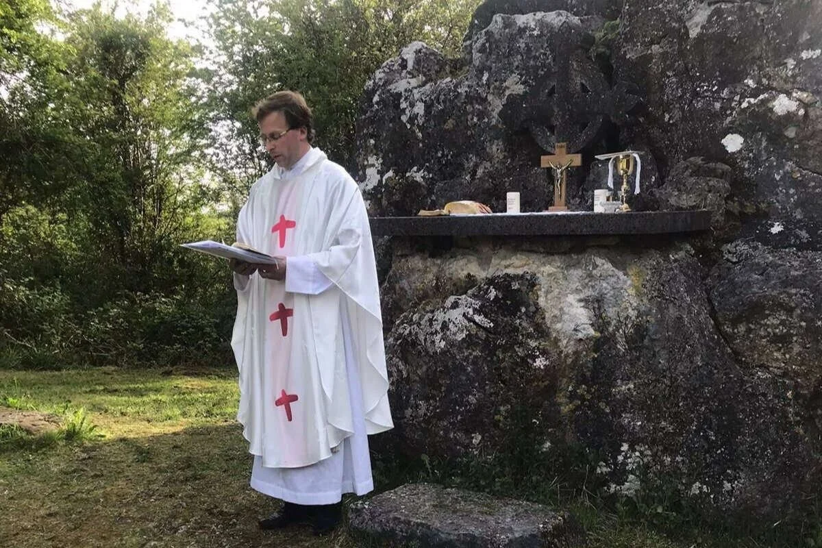 Fr Fergal Cummins stands beside the altar at Clara Mass Rock