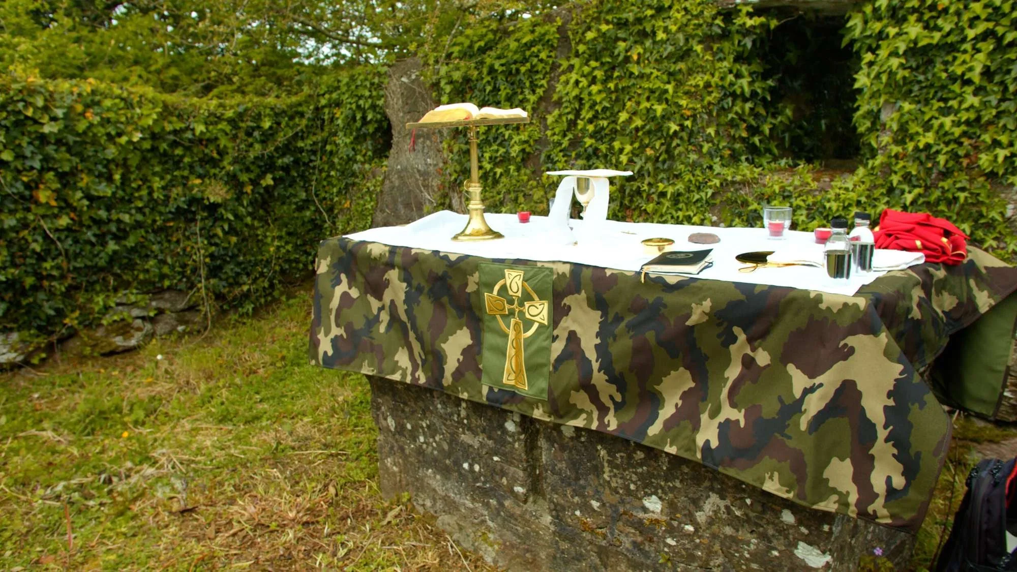 Outdoor stone altar prepared for Mass with candles and vessels