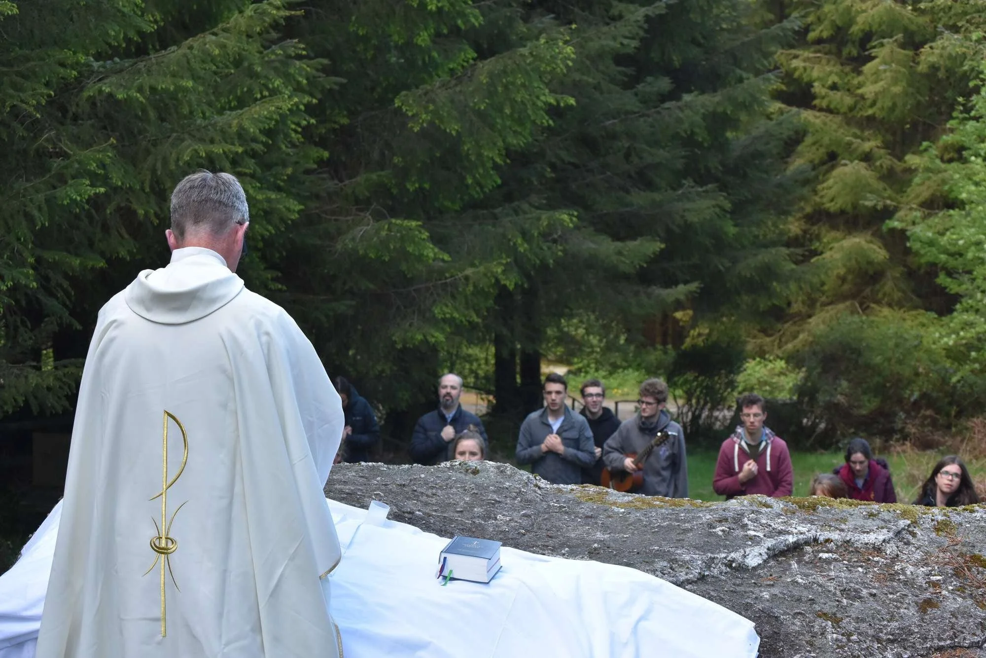 Worshippers face Fr Patrick Cahill at a woodland Mass Rock