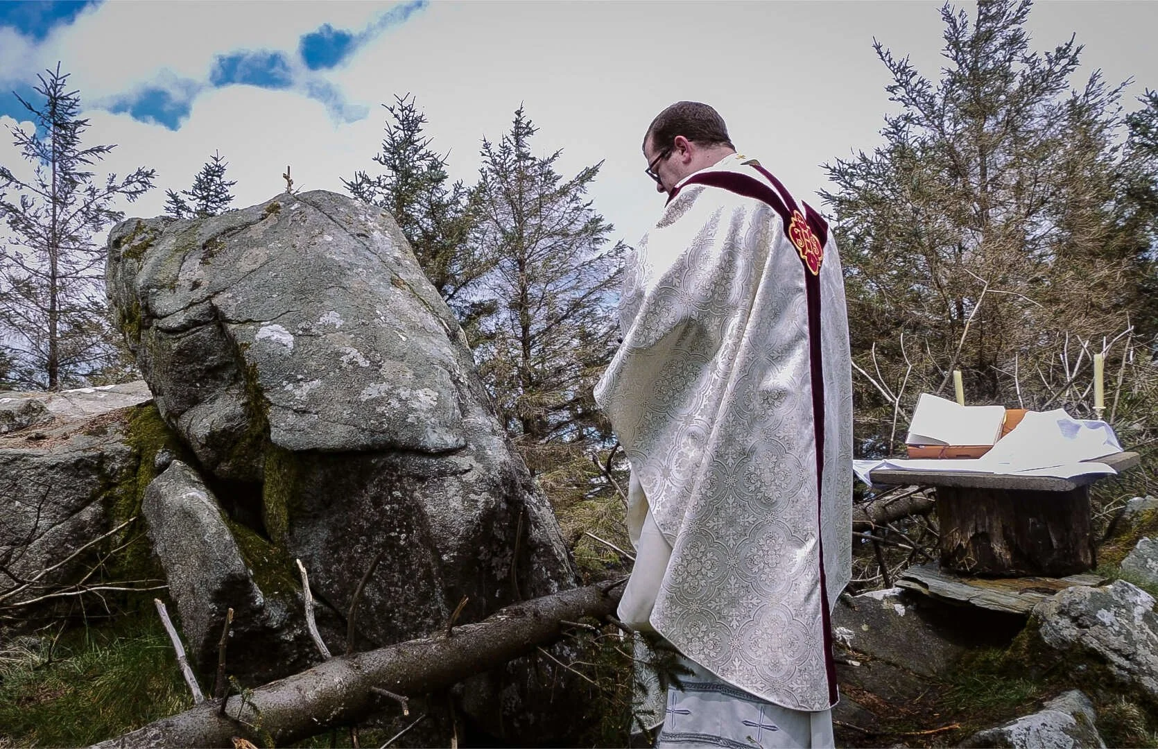 Fr Bill Shaughnessy prays beside a stone cross in the Dublin Mountains