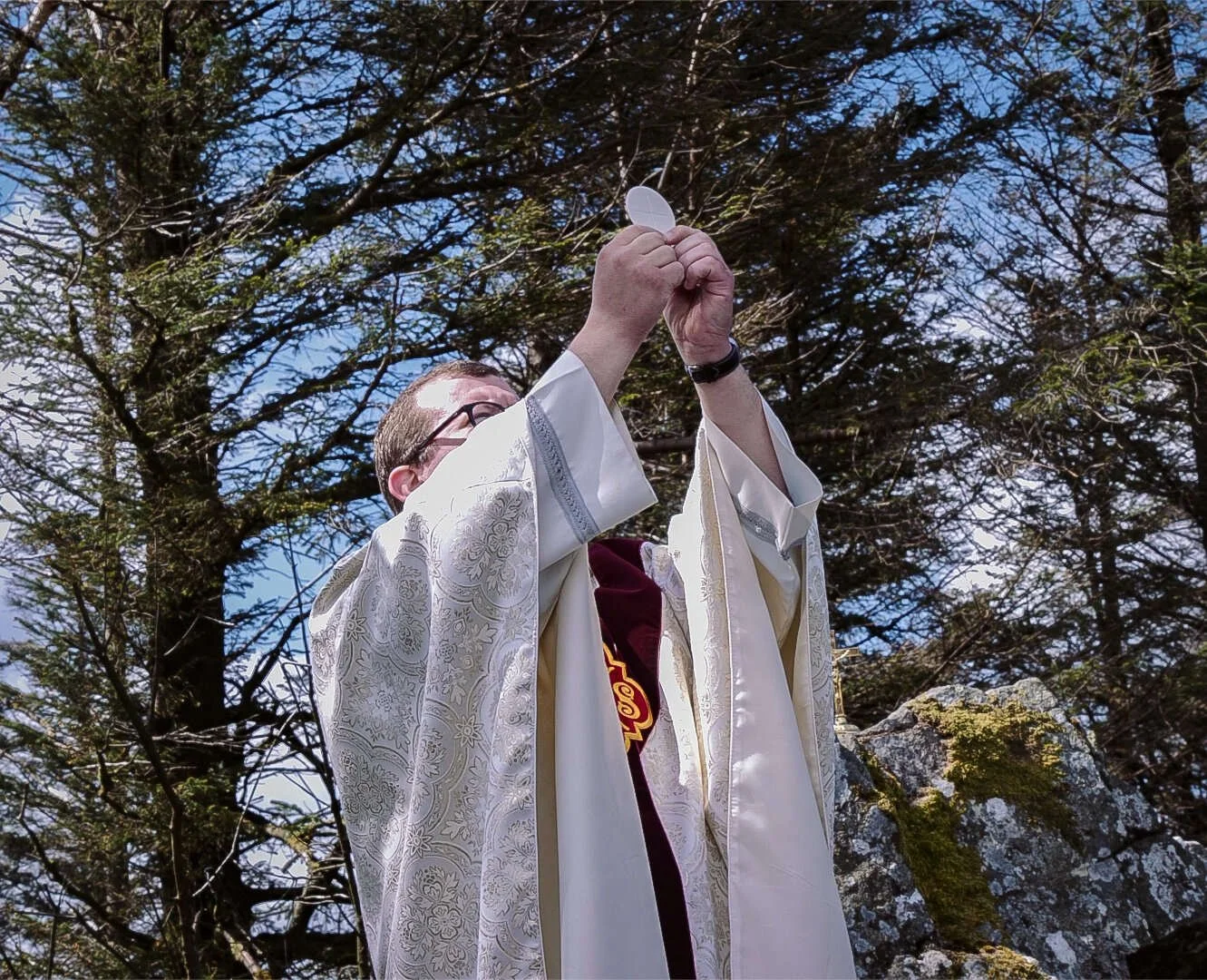 A priest elevates the host during Mass in the Dublin Mountains