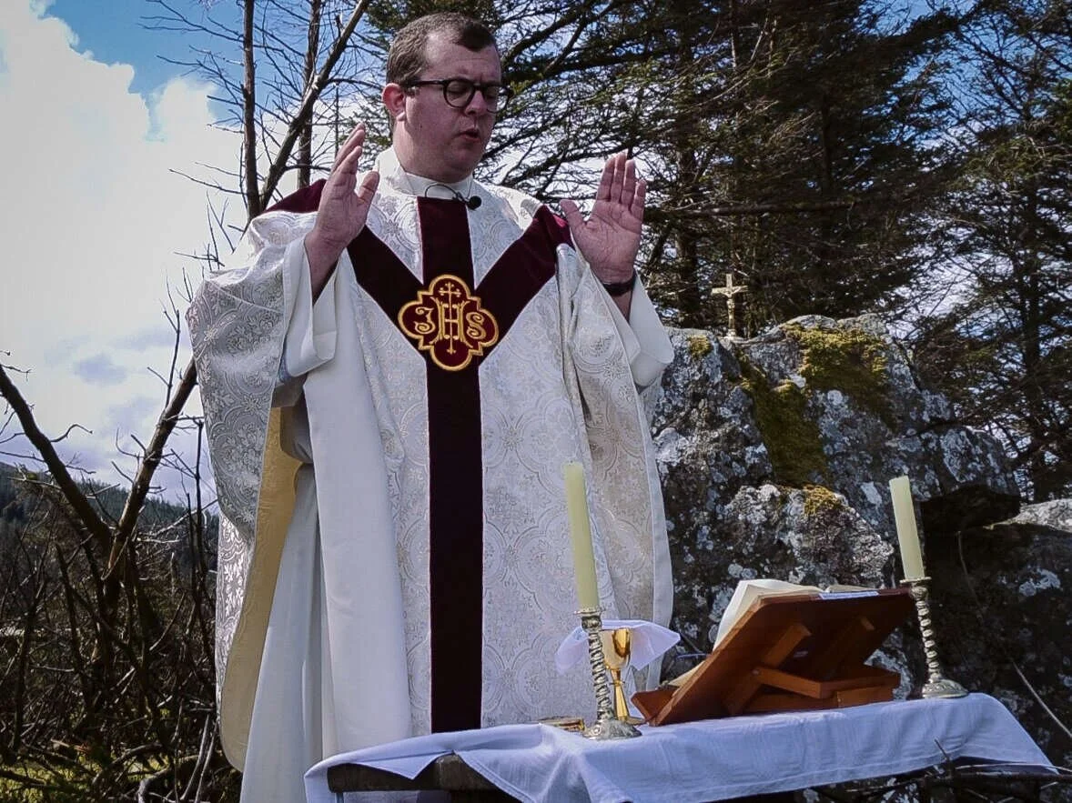 Clergy pray beside an outdoor altar in the Dublin Mountains