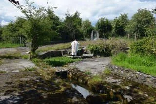 Fr Mark Condon stands behind an outdoor stone altar