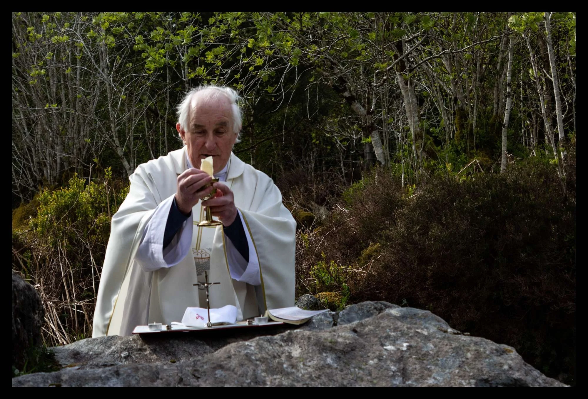 Fr Tommy Johnston elevates a chalice at Mass Hill