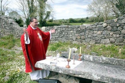 Fr Robert McNamara prays beside a stone altar in Moycullen