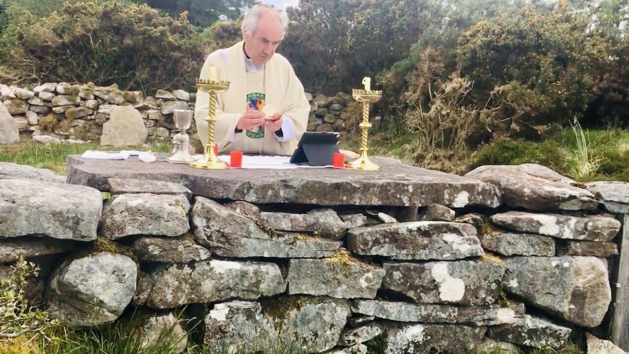 Fr Kieran O’Rourke reads from a missal at Loughatorick Mass Rock