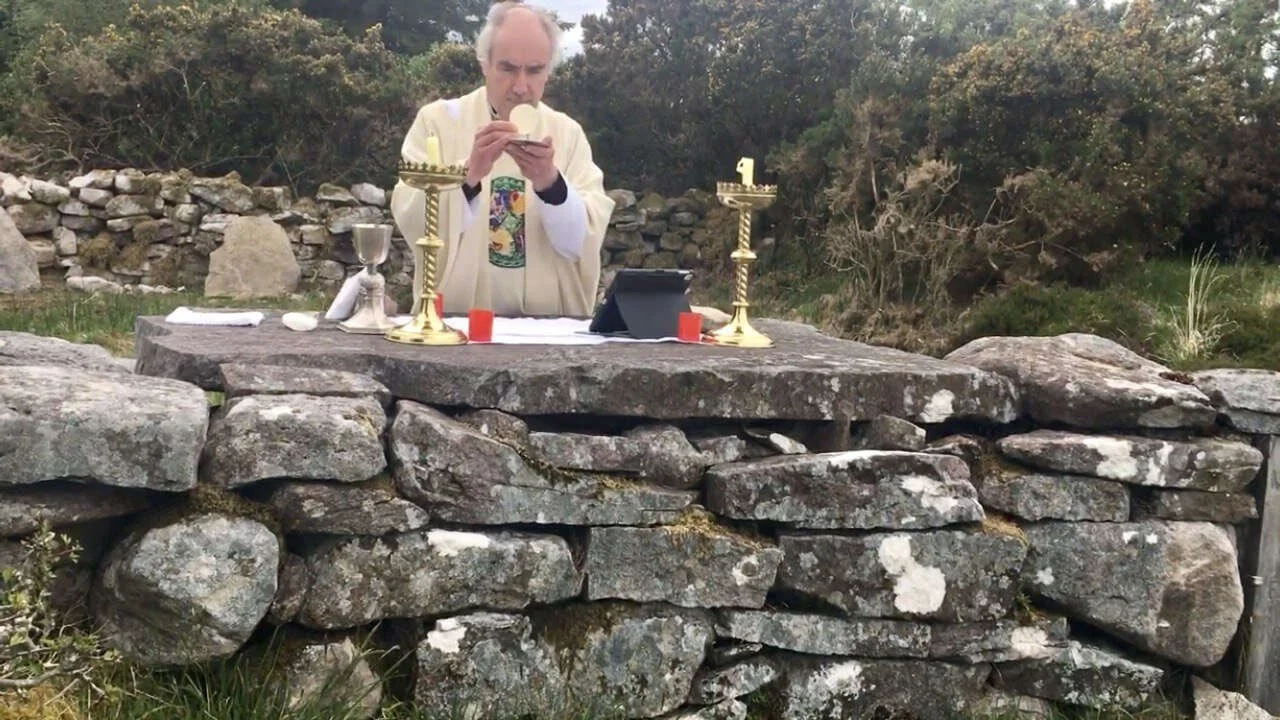 Fr Kieran O’Rourke holds the host at Loughatorick Mass Rock