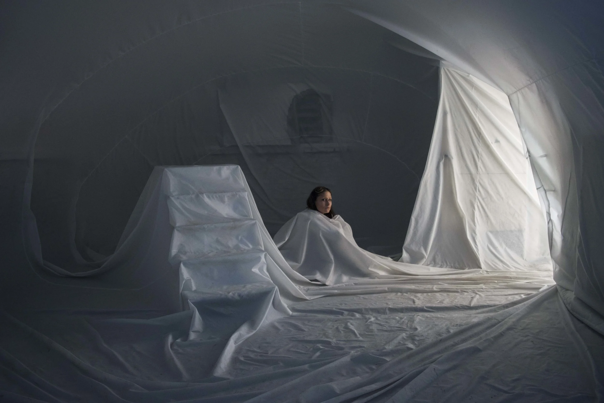 The audience are placed in two parts of the bunker. In the first space the audience walks into the inflatable object through a zipper. The material nestles on the wallsand draws the outline of the bunker.