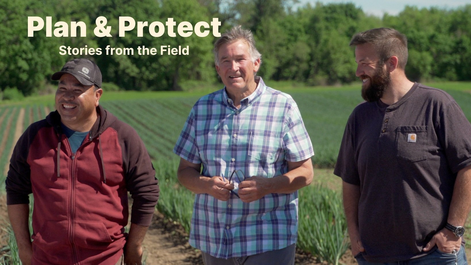 Farmers Oscar Lopez, Skip Gray, and Kevin Gray share a laugh in front of an onion field at GFI