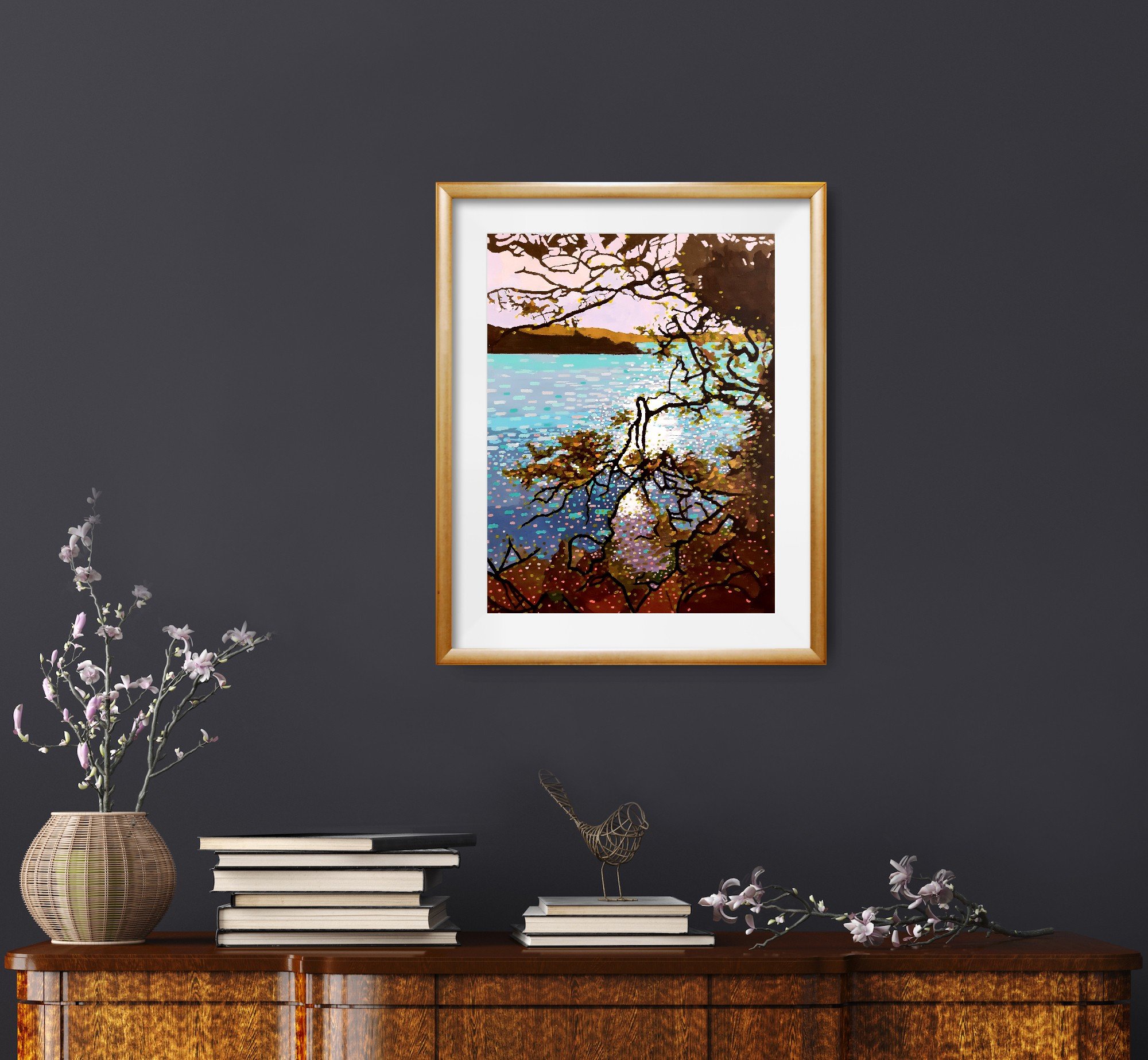 A view of a colourful framed print of a Cornish river through trees with light glinting on the water (Copy)