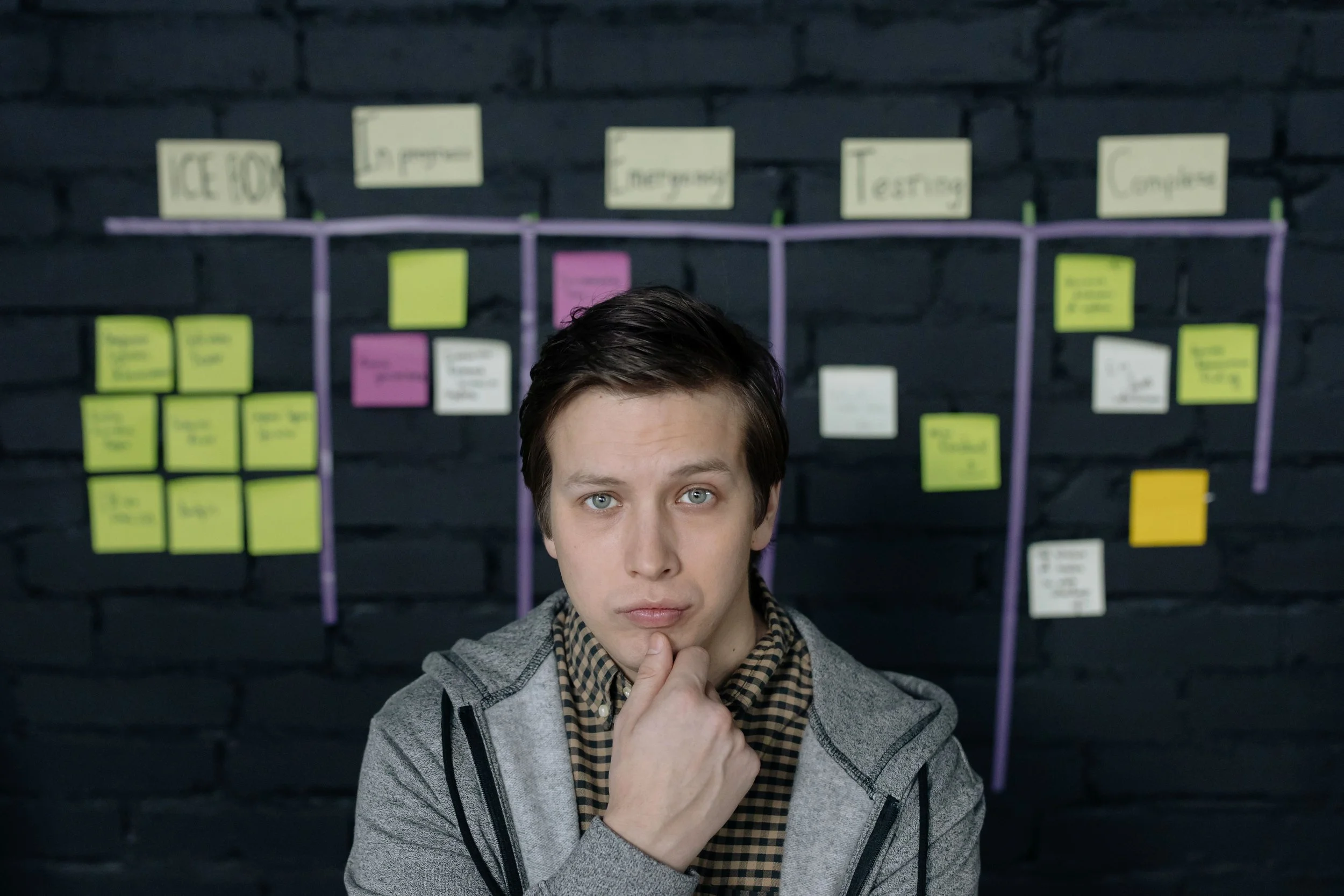 A man in front of a task board