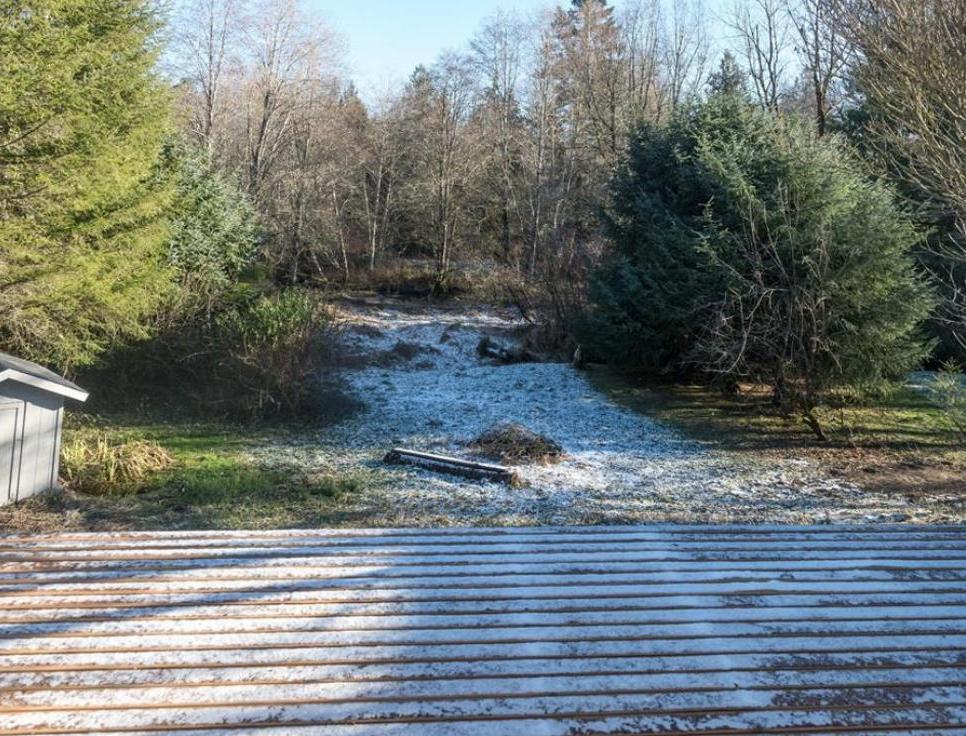 New installed deck overlooking lower back yard with forested river bank beyond.