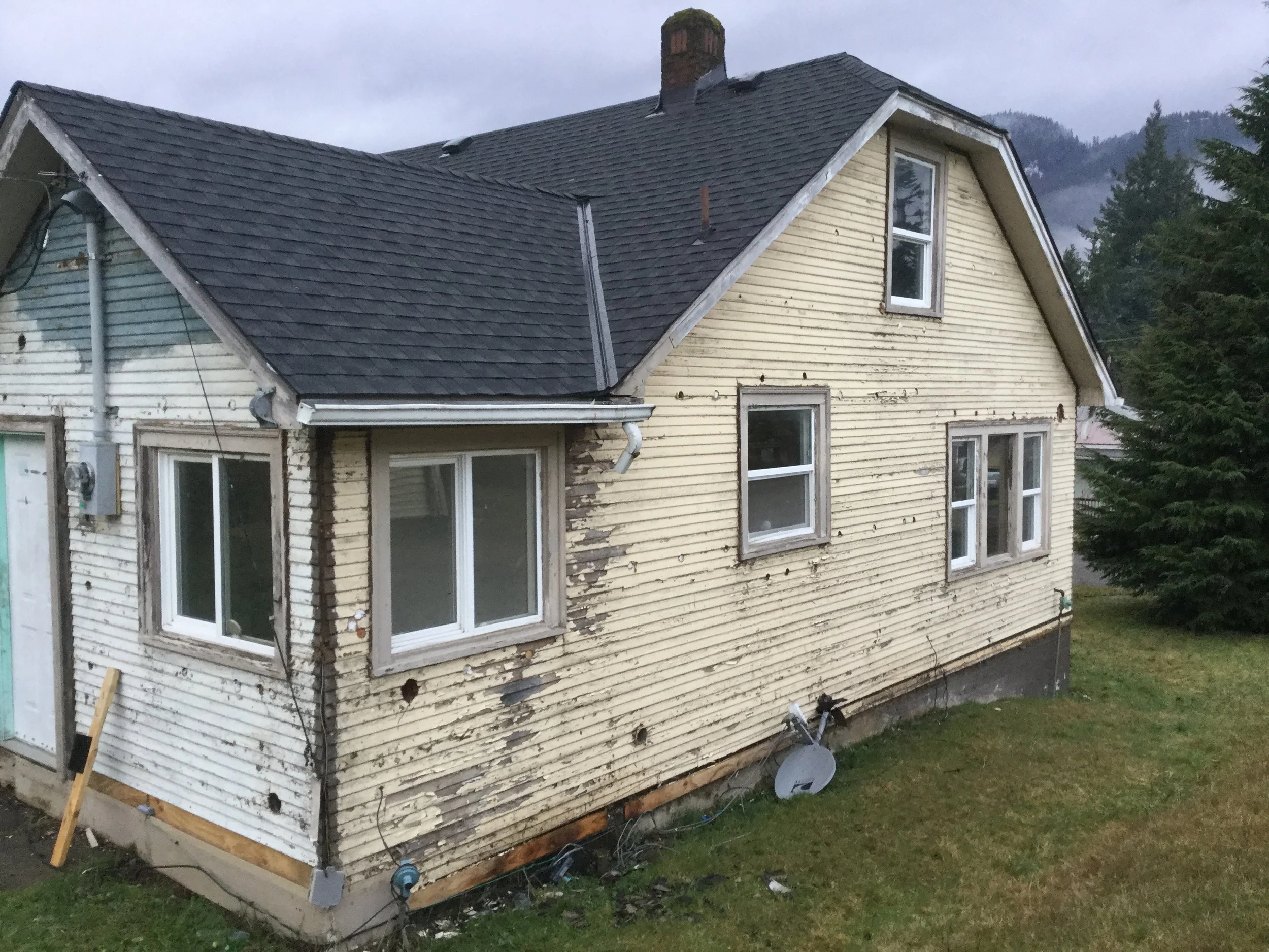 View of back corner of house after overlay siding removed.