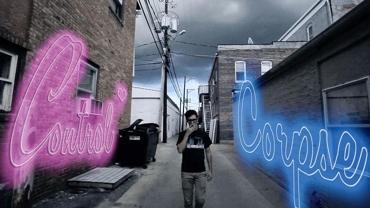 A person walking in an alleyway with dark clouds overhead. Neon signs saying 'Control' in pink on the left wall and 'Courage' in blue on the right wall
