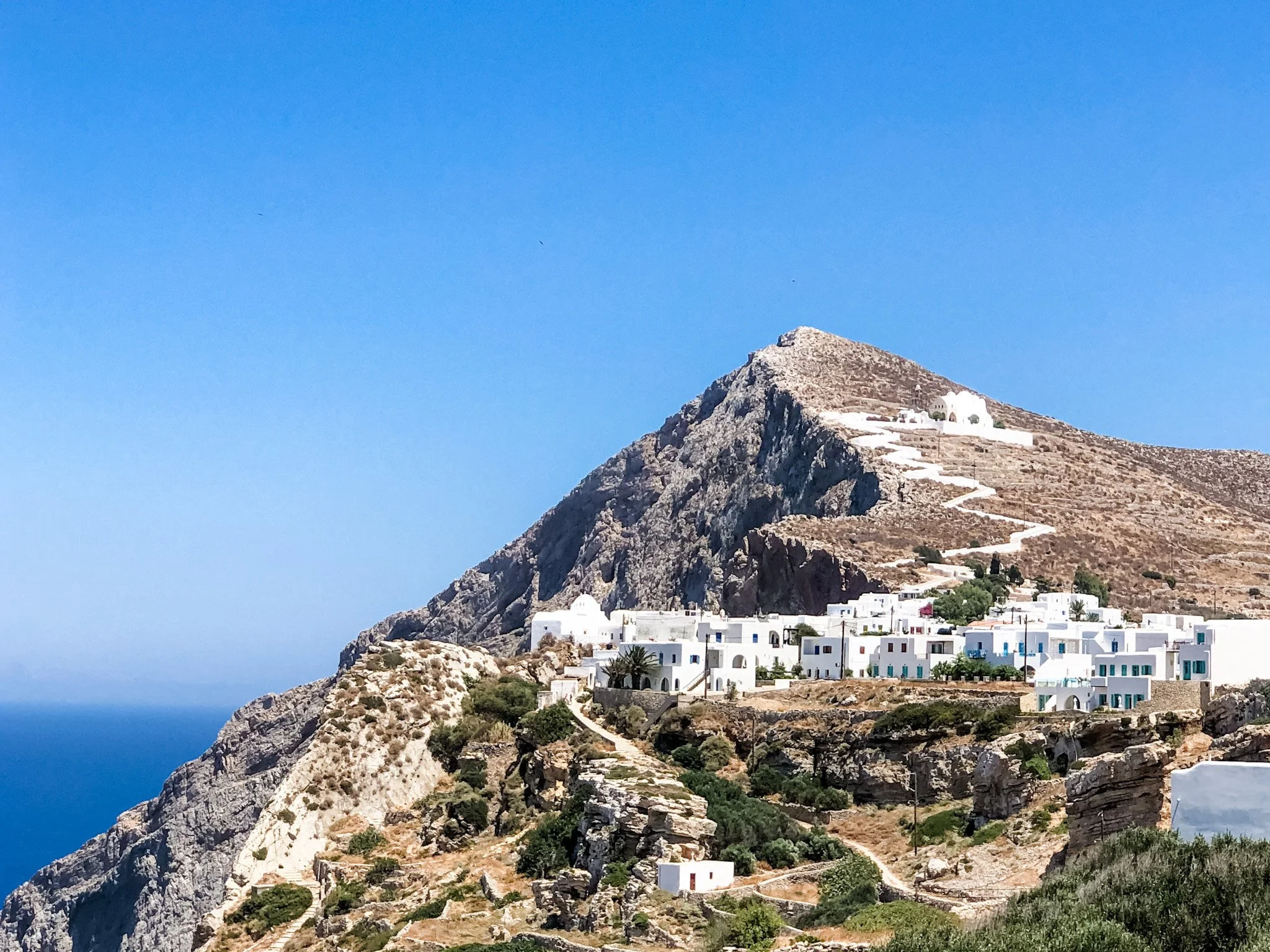 Chora Folegandros from a distance with the Panagia Church perched high up the mountain with the Aegean in the background