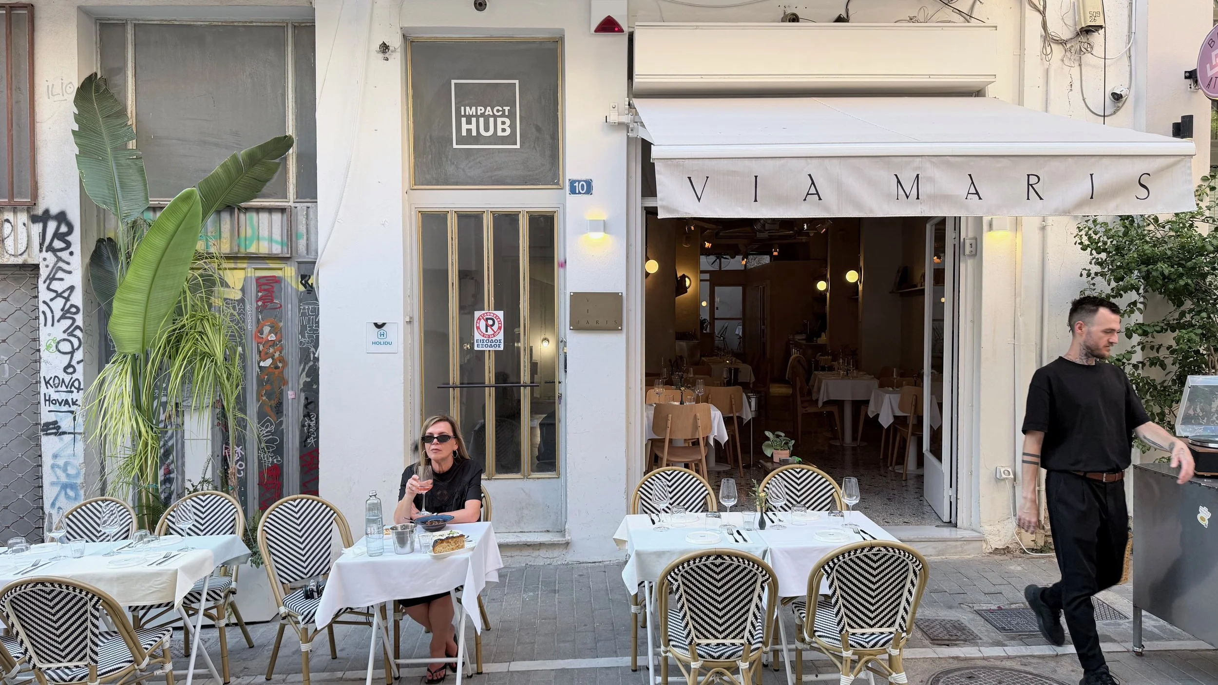 Solo female traveller dining alone at Via Maris restaurant in Athens, Greece.