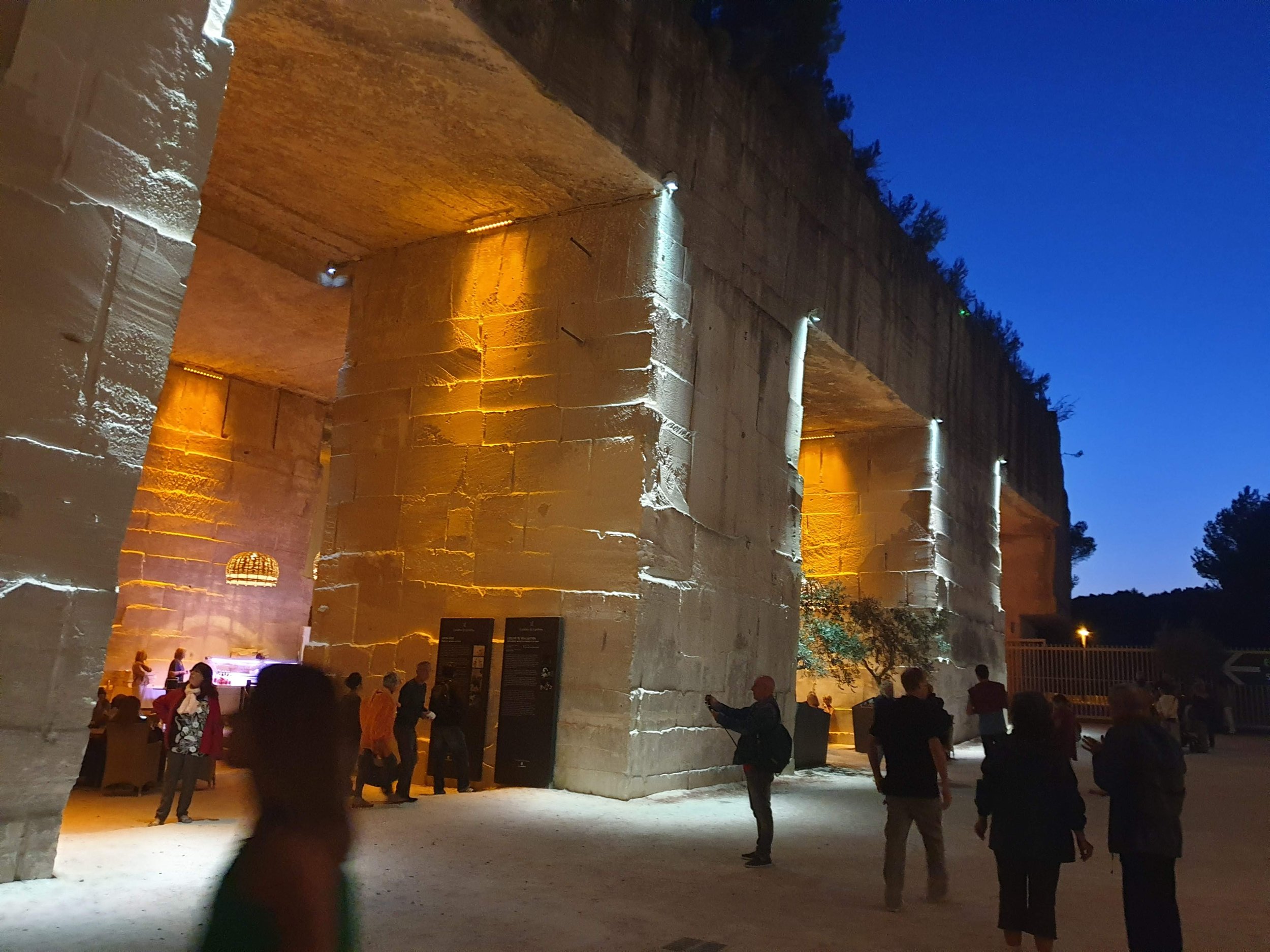 Evening visit at Les Carrières de Lumières in Les Baux-de-Provence with visitors taking photos of immersive art projections