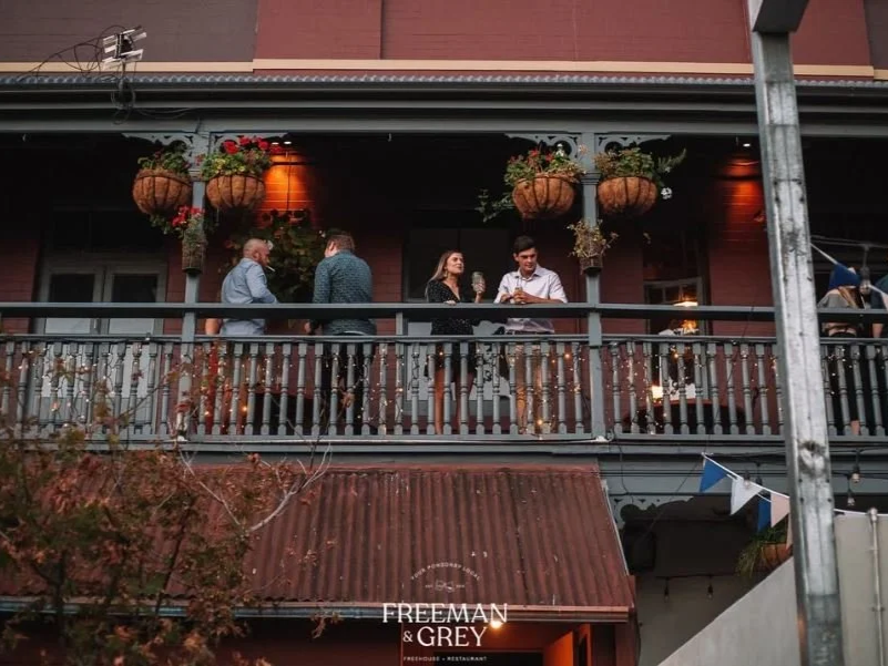 Guests enjoying drinks on the upstairs balcony at Freeman & Grey in Ponsonby
