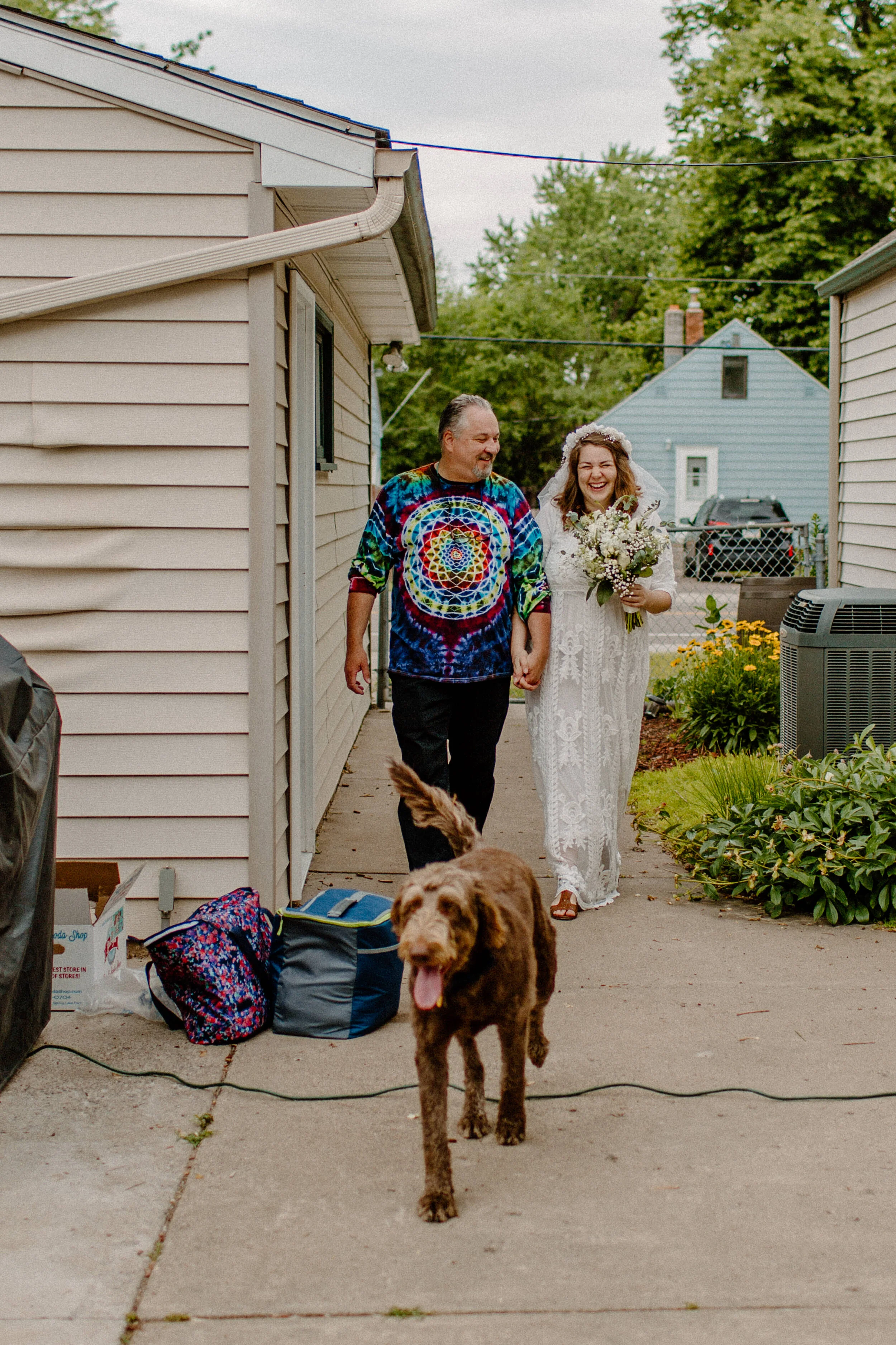 bride walks down the aisle with her dad and dog at cute backyard wedding in minneapolis minnesota, traveling wedding photographer
