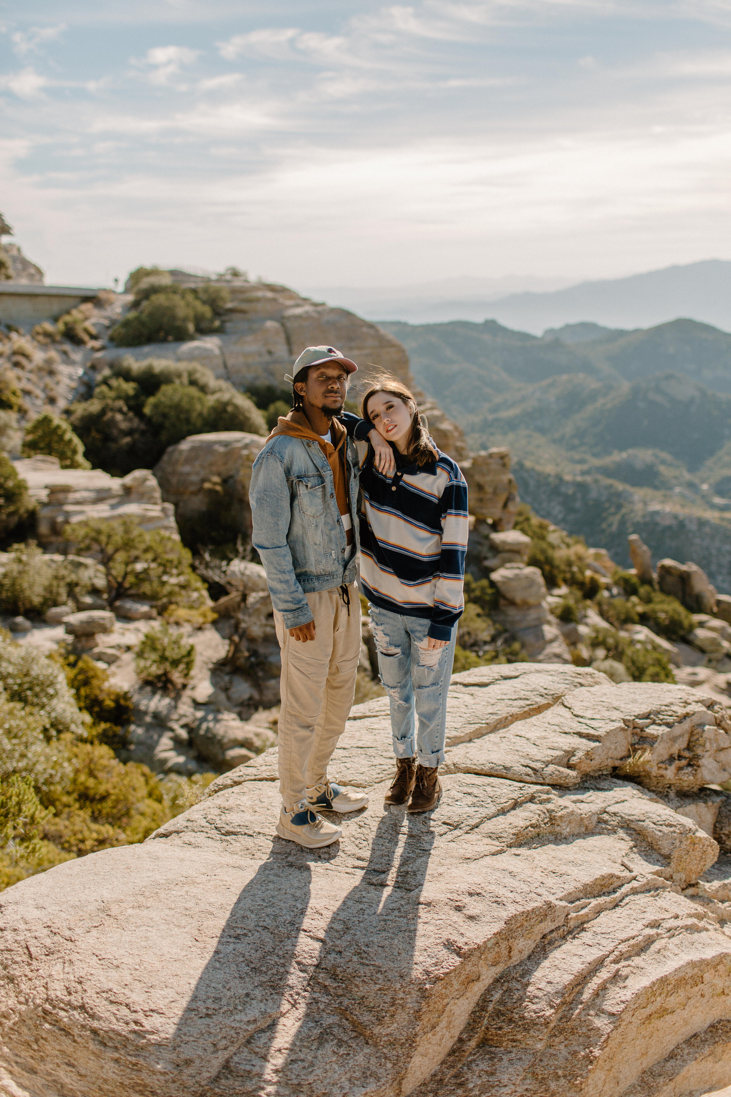  Woman leaning on her boyfriend’s shoulder while standing on a rock at Windy Point on Mount Lemmon in Tucson Arizona. Arizona couples photographer, Lucy B. Photography. 