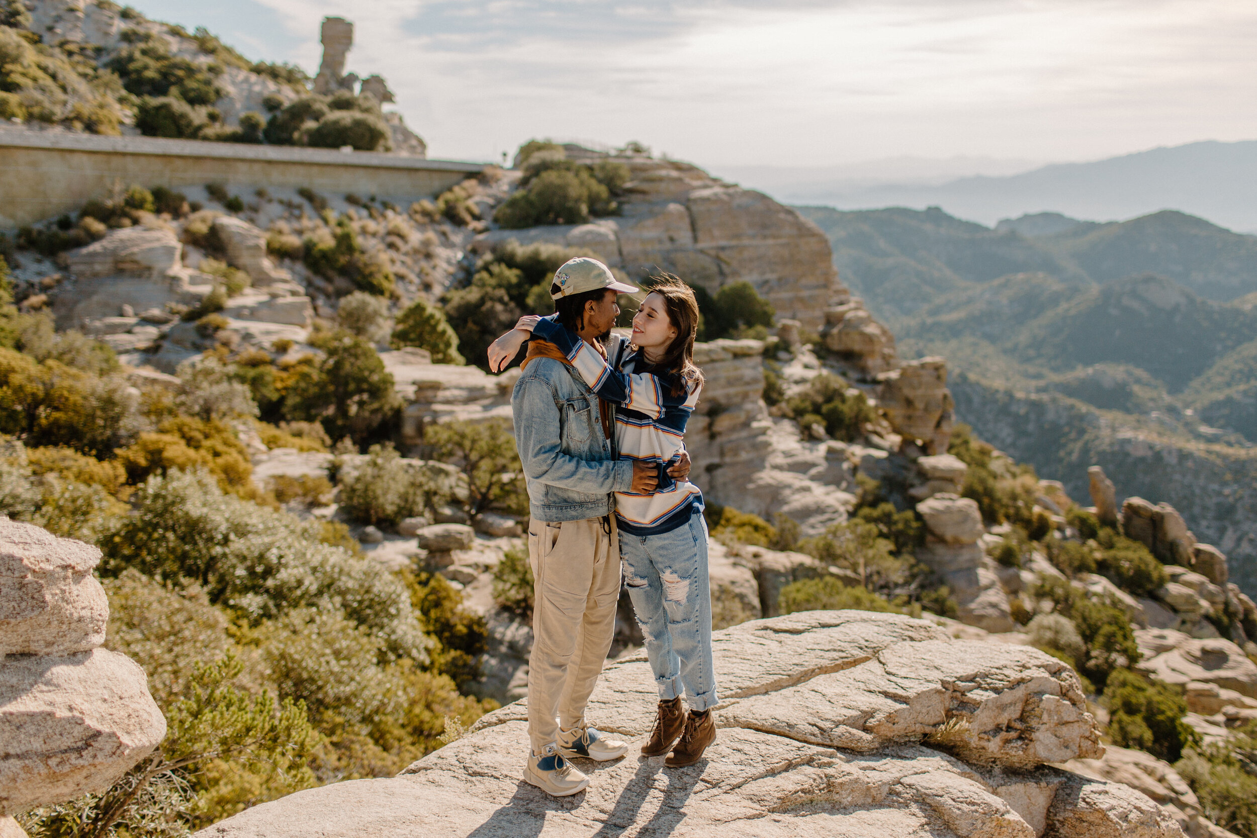  Woman stands with her arms around her boyfriend’s shoulders as they smile at each other at Windy Point on Mount Lemmon in Tucson Arizona. Arizona couples photographer, Lucy B. Photography. 