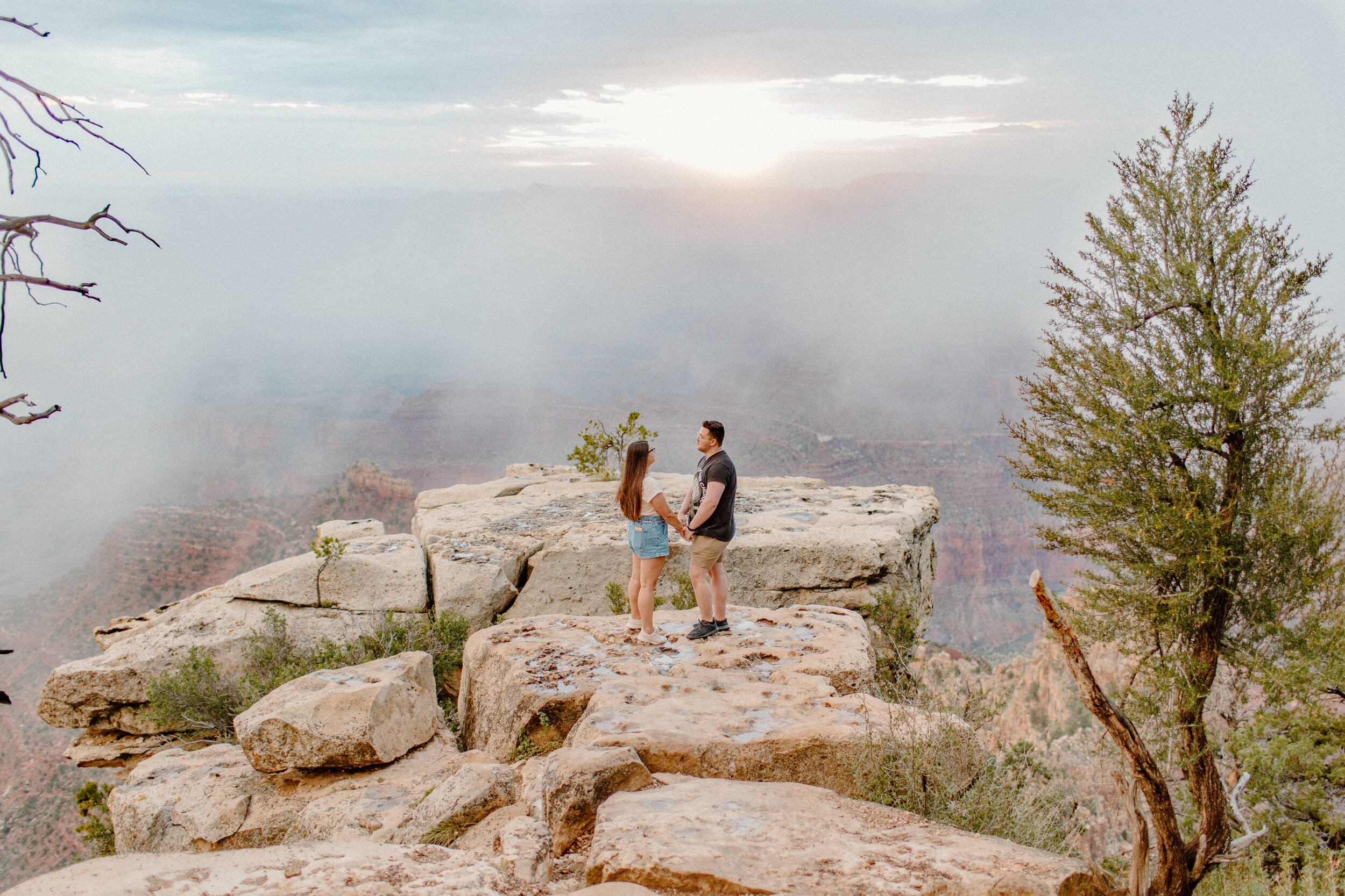  Surprise proposal at sunrise at the Grand Canyon. Man and woman stand looking at each other at the rim of the Grand Canyon at Grandview Point. Grand Canyon engagement, Lucy B. Photography. 