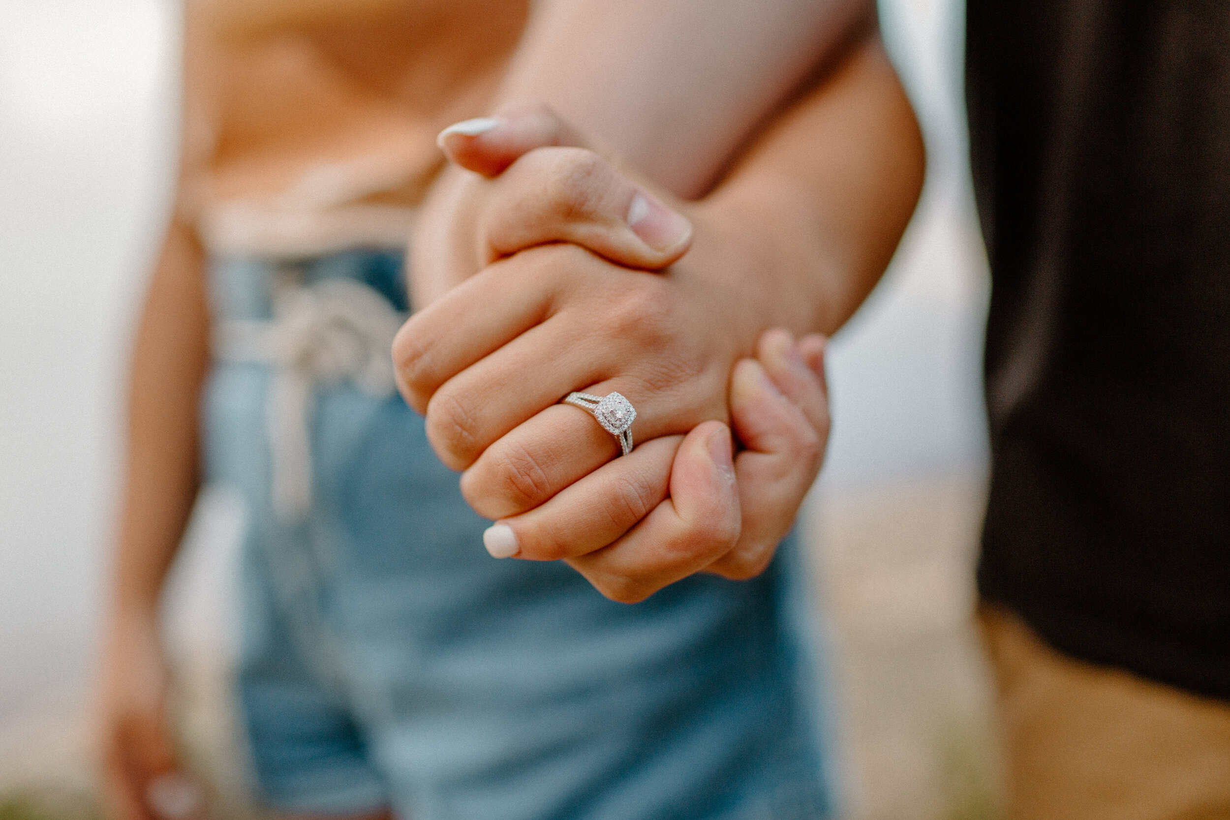  Surprise proposal at sunrise at the Grand Canyon. Close up photo of a couple holding hands and showing off the woman’s new engagement ring at the rim of the Grand Canyon at Grandview Point. Grand Canyon engagement, Lucy B. Photography. 