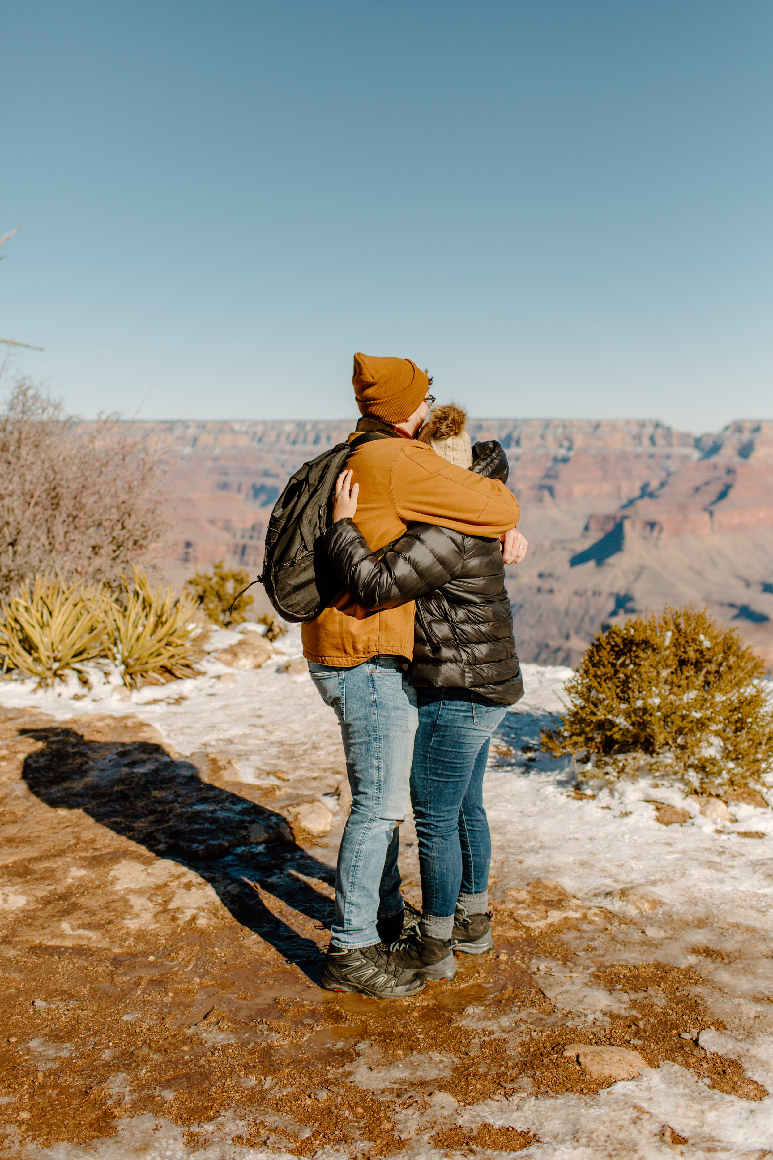  Surprise proposal at the Grand Canyon on the Rim Trail, couple shares an emotional hug right after becoming engaged at the rim of the Grand Canyon. Grand Canyon engagement photographer, Grand Canyon proposal photographer, Lucy B. Photography. 