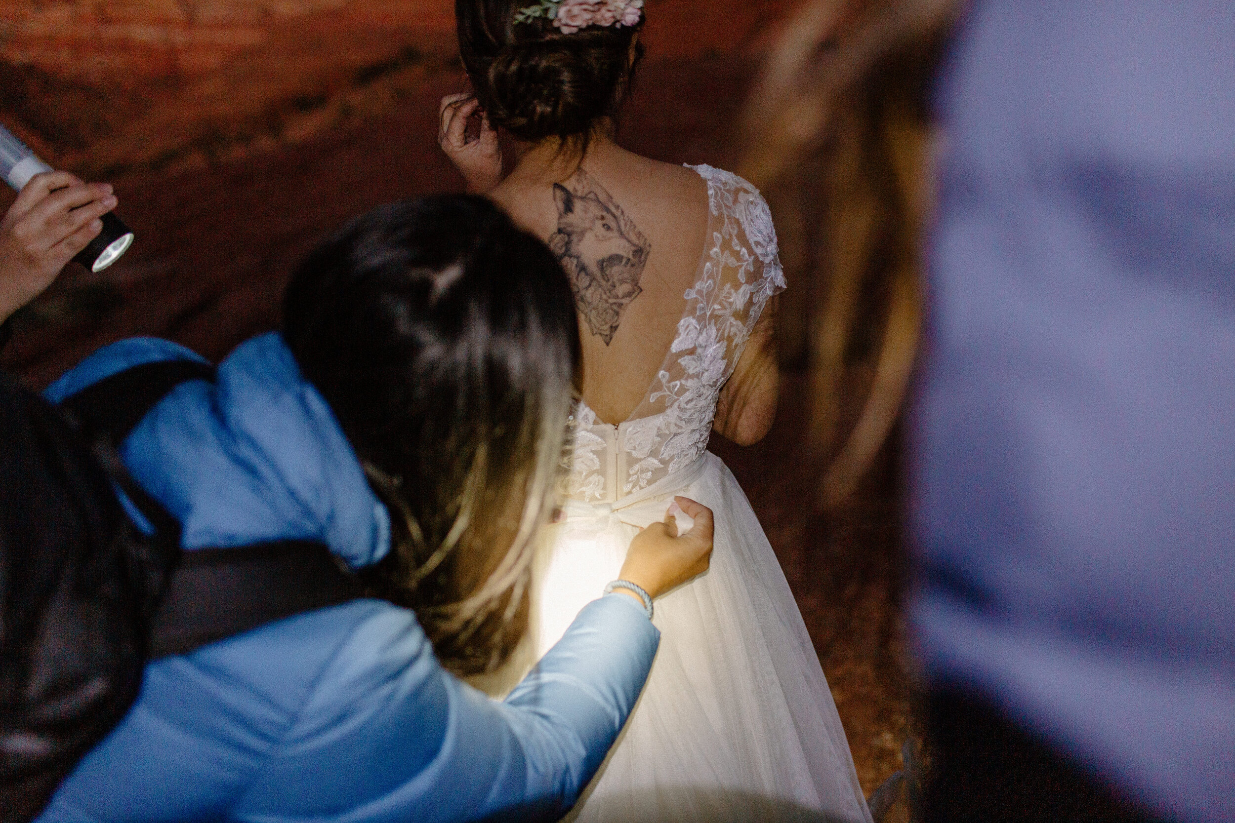  Women help bride get ready by flashlight for her Utah elopement at Snow Canyon State Park in St. George Utah. Utah elppement photographer, Lucy B. Photography. 