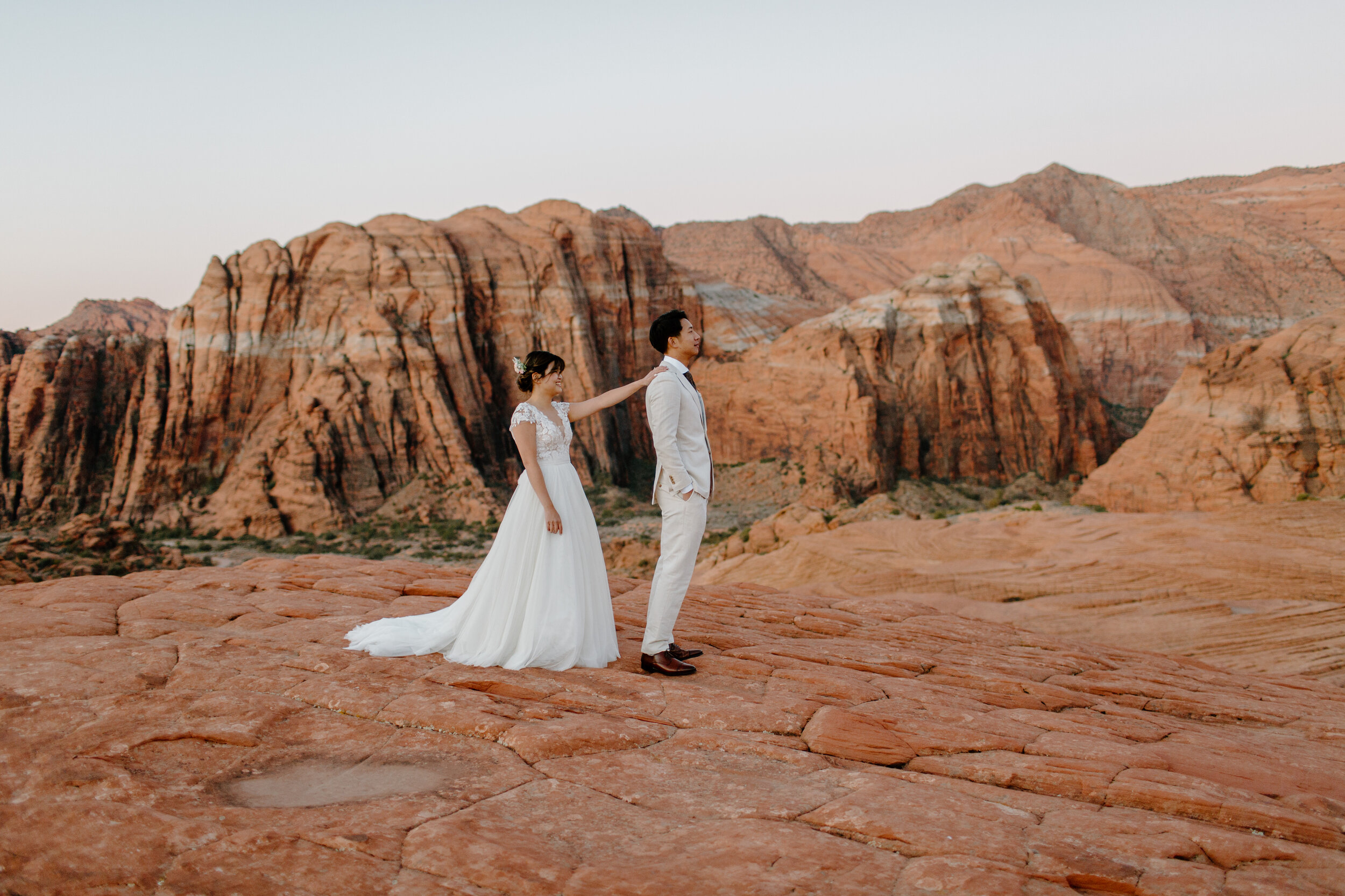 Bride taps groom on the shoulder for first look at Snow Canyon State Park in St. George Utah. Utah elopement photographer, Lucy B. Photography. 