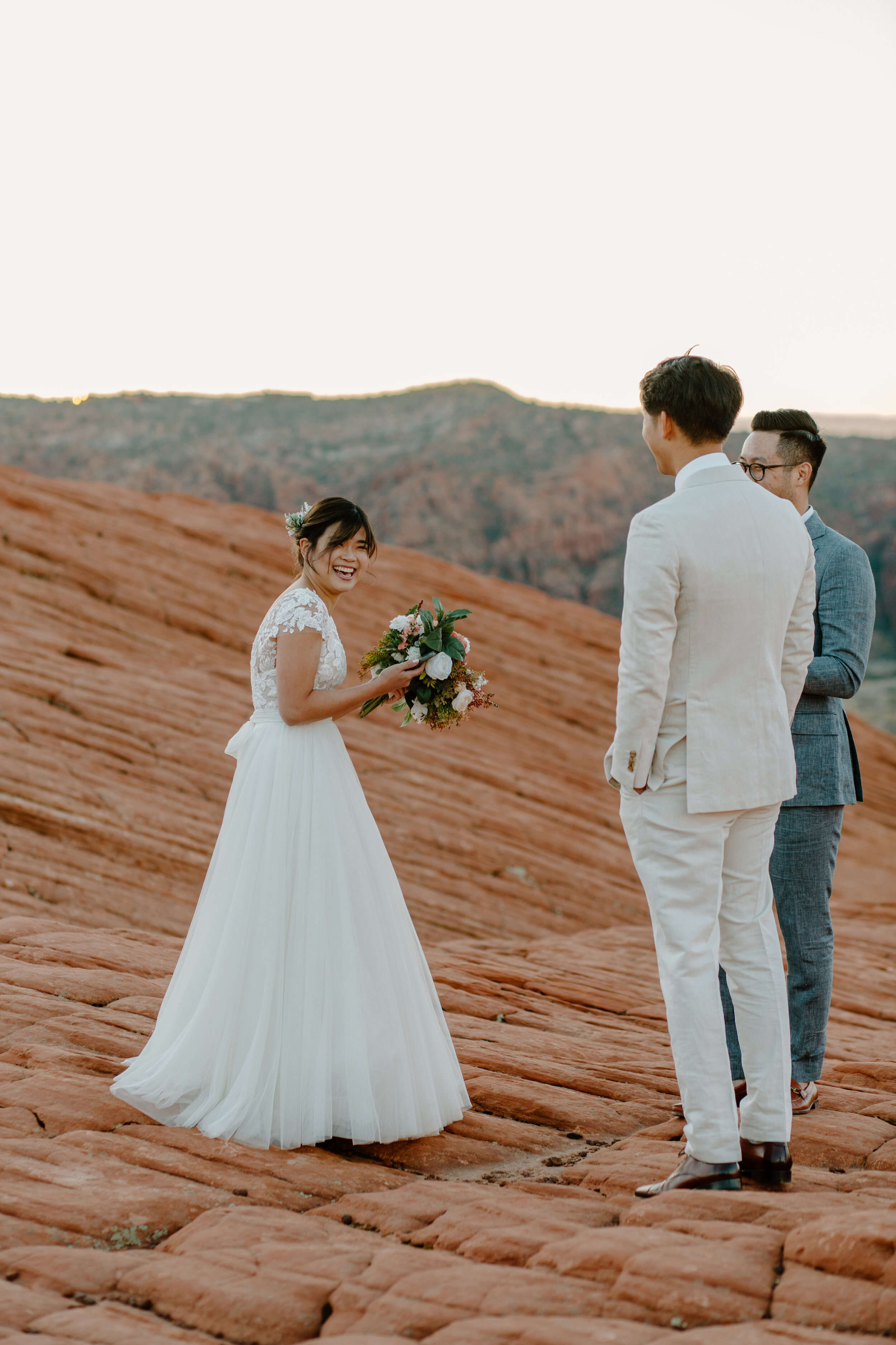  Bride laughs after reading her vows to her groom during their Utah elopement at Snow Canyon State Park in St. George Utah. Utah elopement photographer, Lucy B. Photography. 