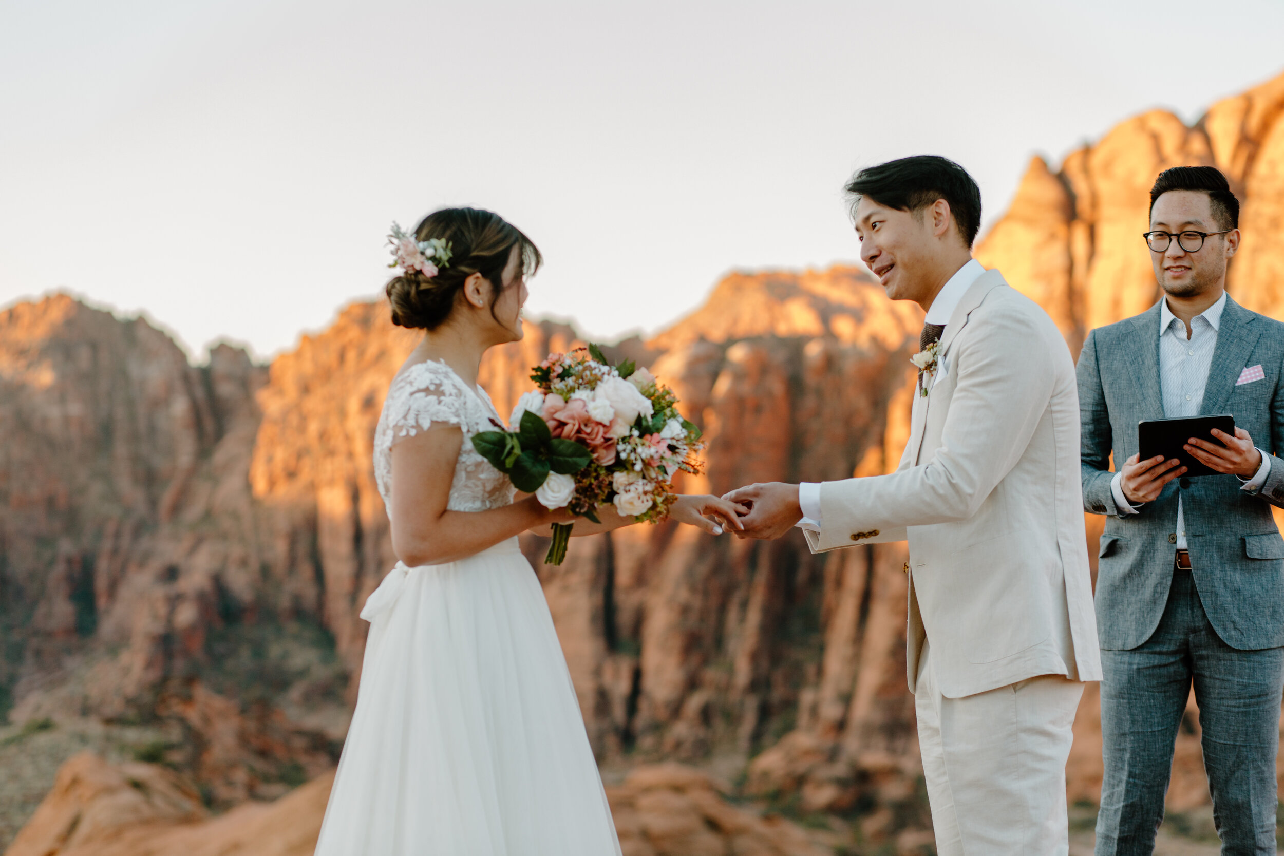  Groom puts wedding band on his new wife’s finger during their Utah elopement at Snow Canyon State Park in St. George Utah. Utah elopement photographer, Lucy B. Photography. 