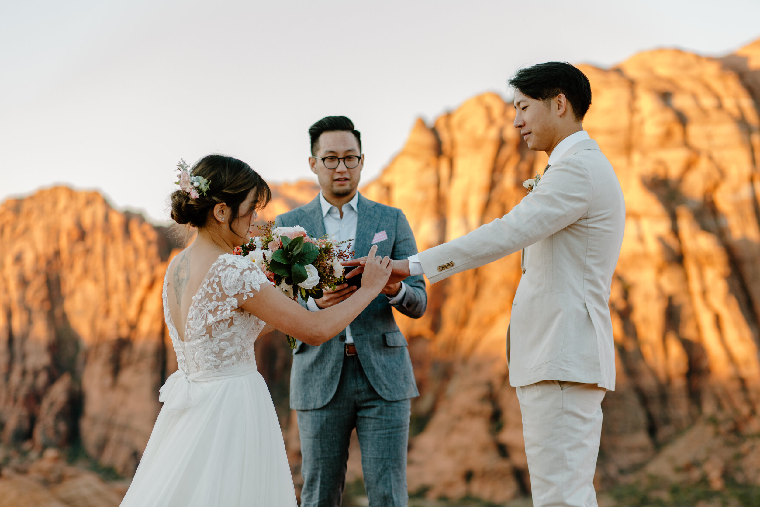  Bride puts a wedding band on her new husband’s finger during their Utah elopement at Snow Canyon State Park in St. George Utah. Utah elopement photographer, Lucy B. Photography. 