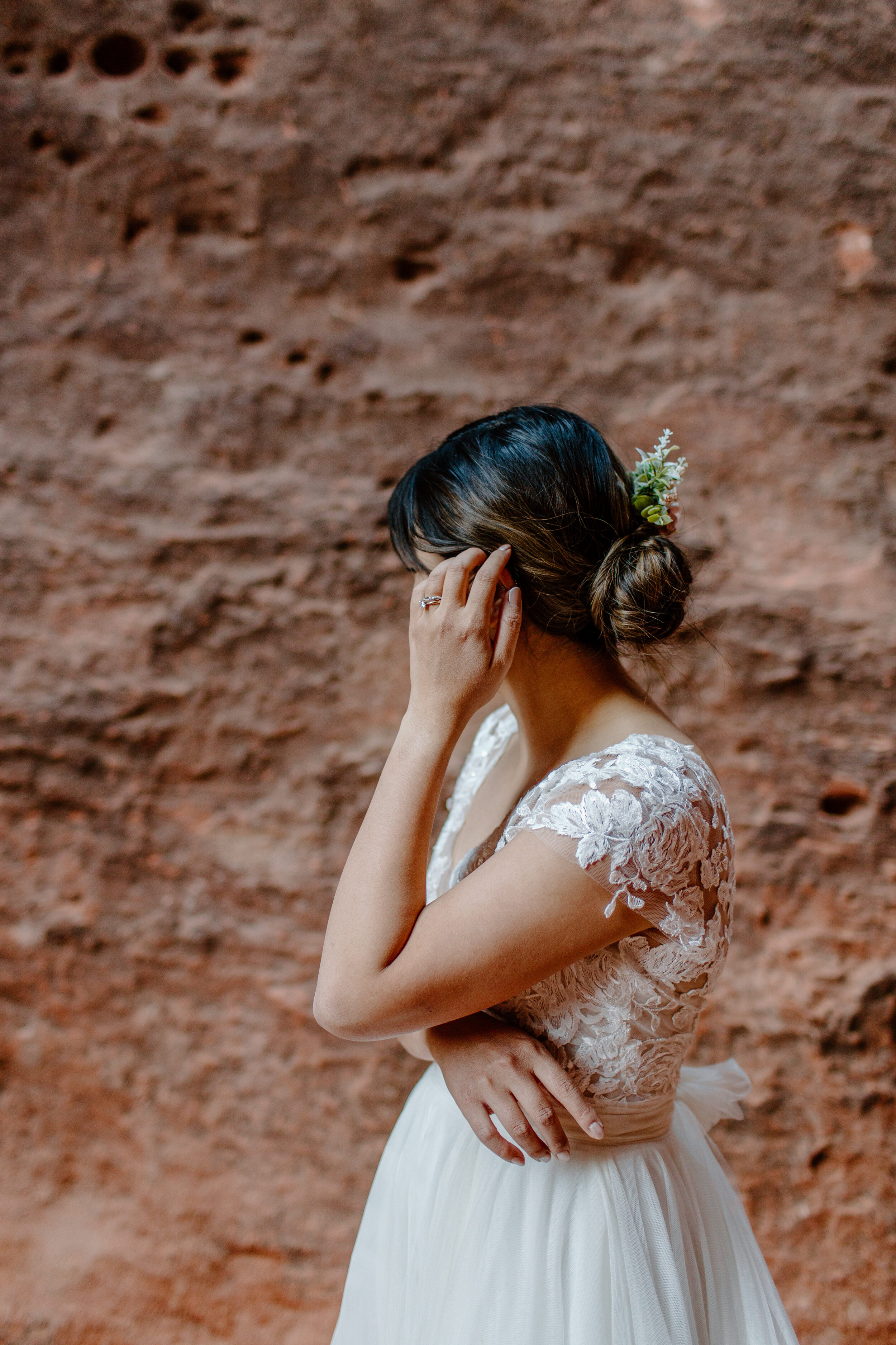  Utah elopement bride tucks her hair behind her ear showing off her wedding ring at Snow Canyon State Park in St. George Utah. Utah elopement photographer, Lucy B. Photography. 