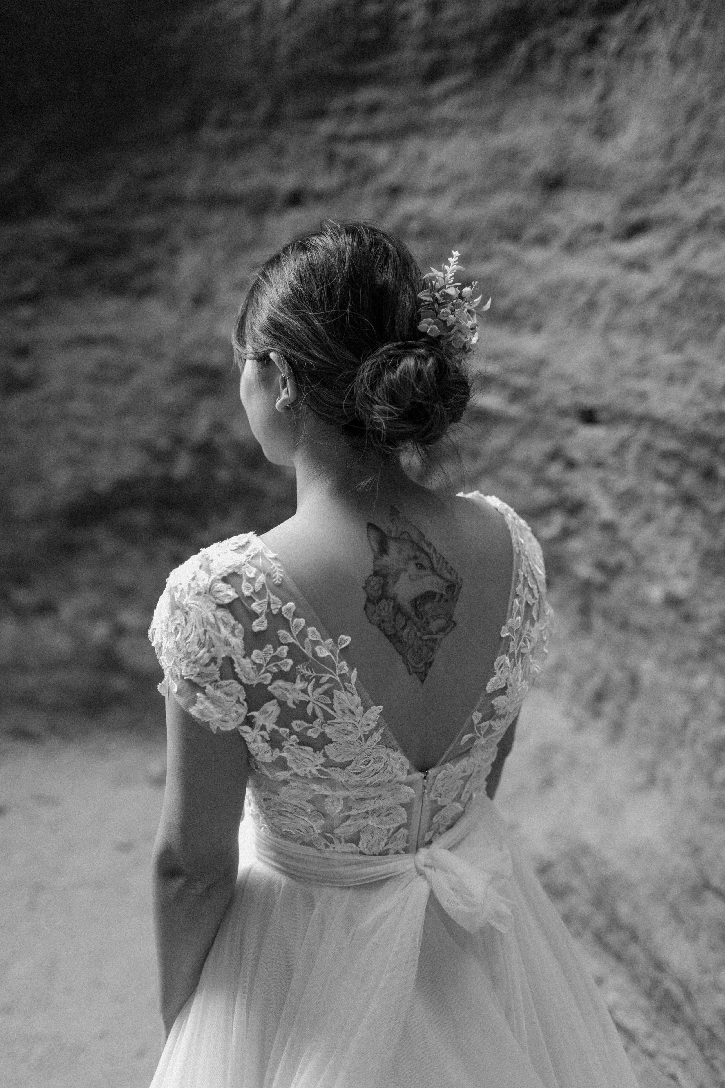  Black and white photo of Utah elopement bride’s back tattoo of a wolf at Snow Canyon State Park in St. George Utah. Utah elopement photographer, Lucy B. Photography. 