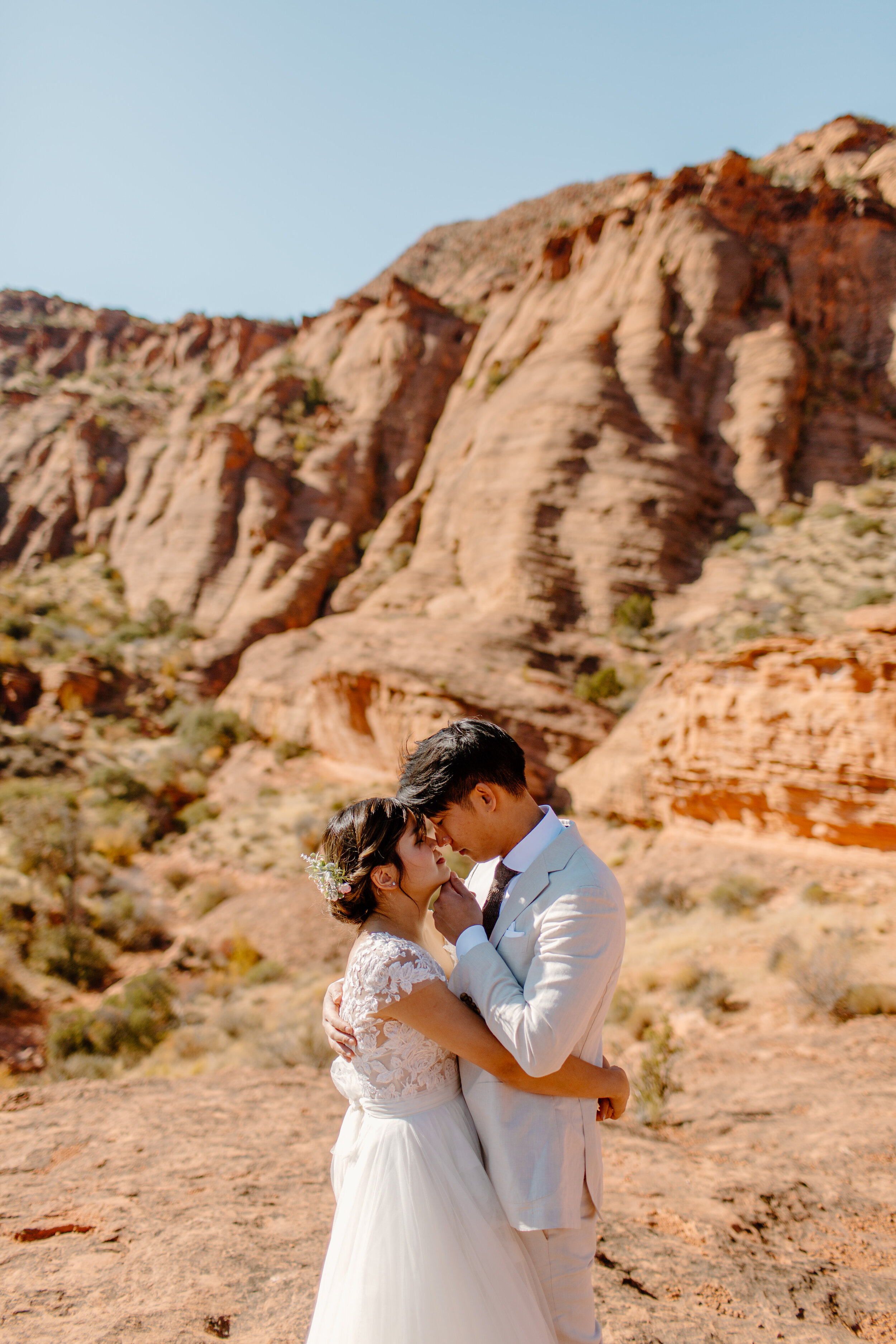  Utah elopement couple holds each other and touches foreheads in front of a mountain in St. George Utah. Utah elopement photographer, Lucy B. Photography. 
