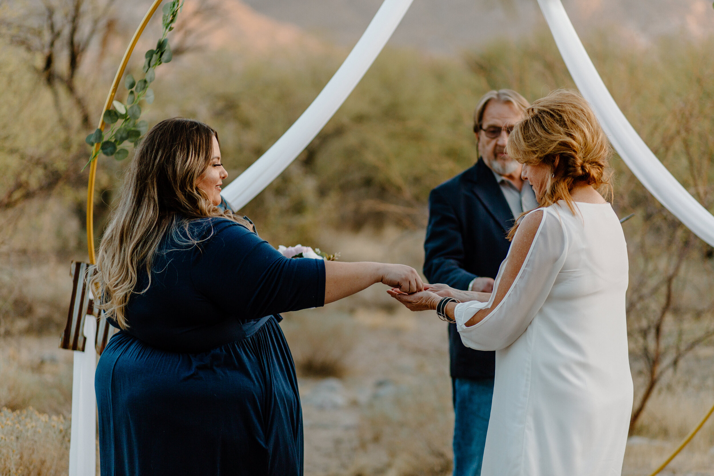  Bride’s daughter hands her the wedding bands during elopement in Catalina State Park in Tucson. Tucson elopement photographer, Lucy B. Photography. 