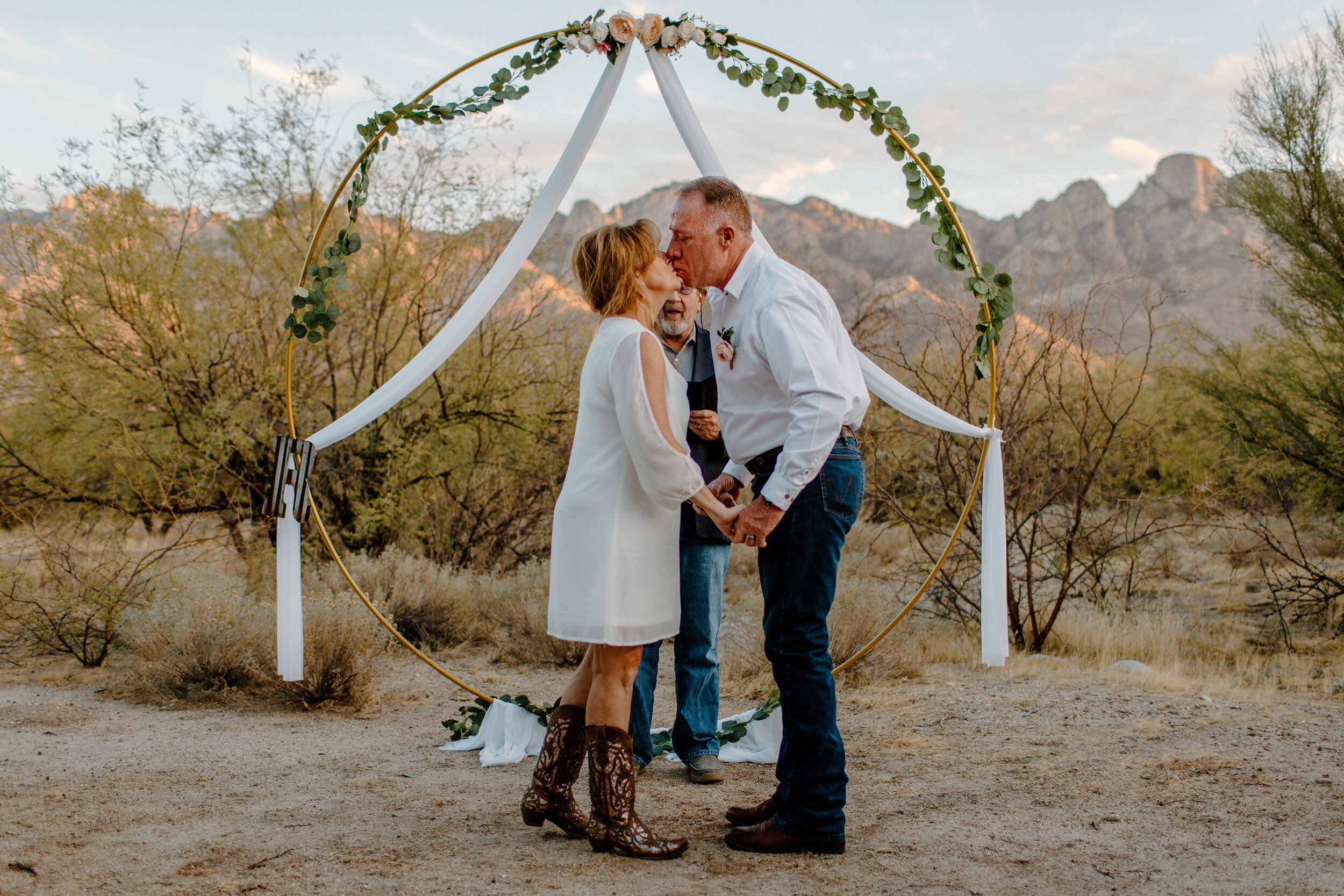  Elopement couple shares their first kiss as husband and wife in front of a mountain backdrop in Catalina State Park in Tucson. Tucson elopement photographer, Lucy B. Photography. 