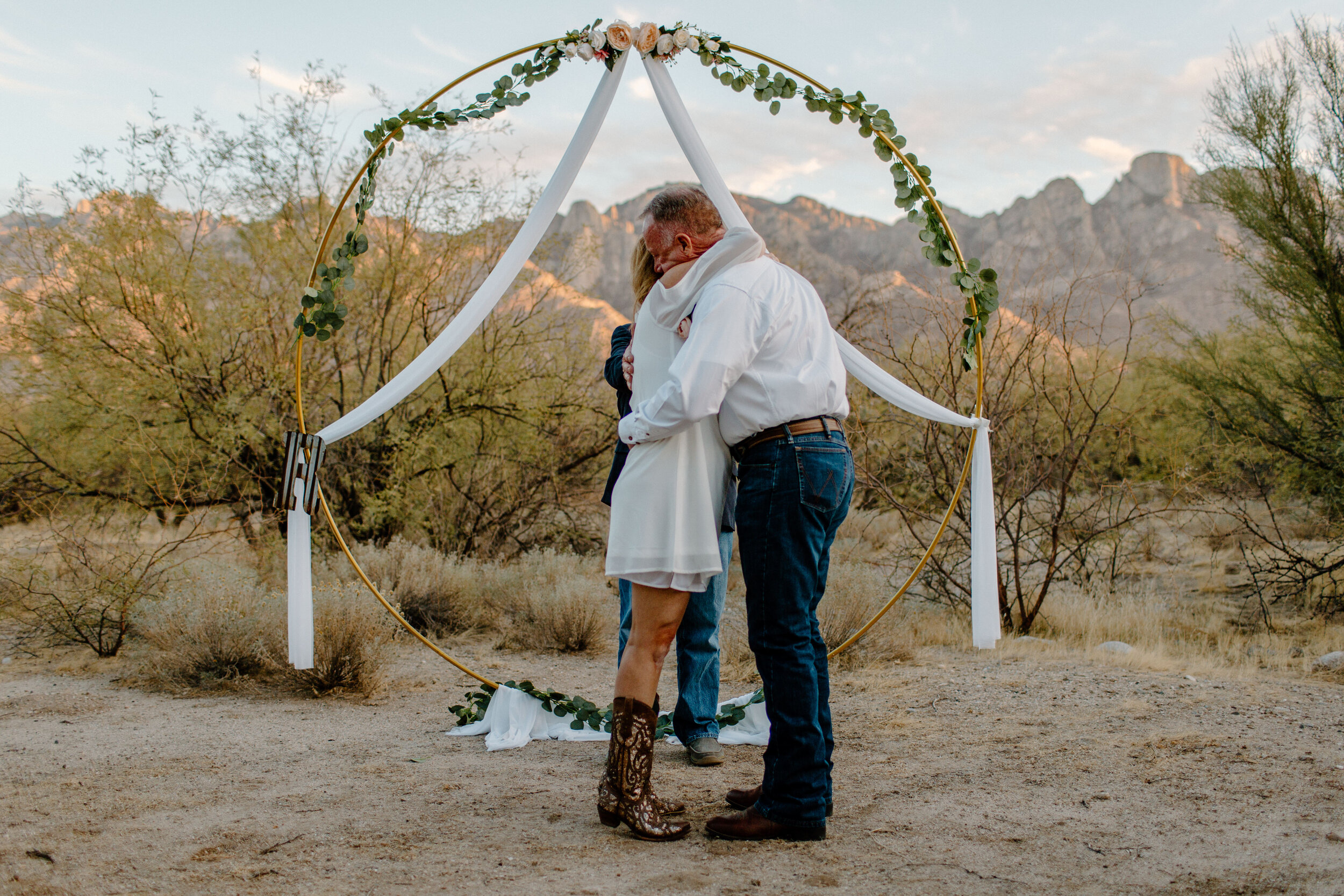  Bride and groom share a hug after their first kiss in front of a mountain backdrop in Catalina State Park in Tucson. Tucson elopement photographer, Lucy B. Photography. 