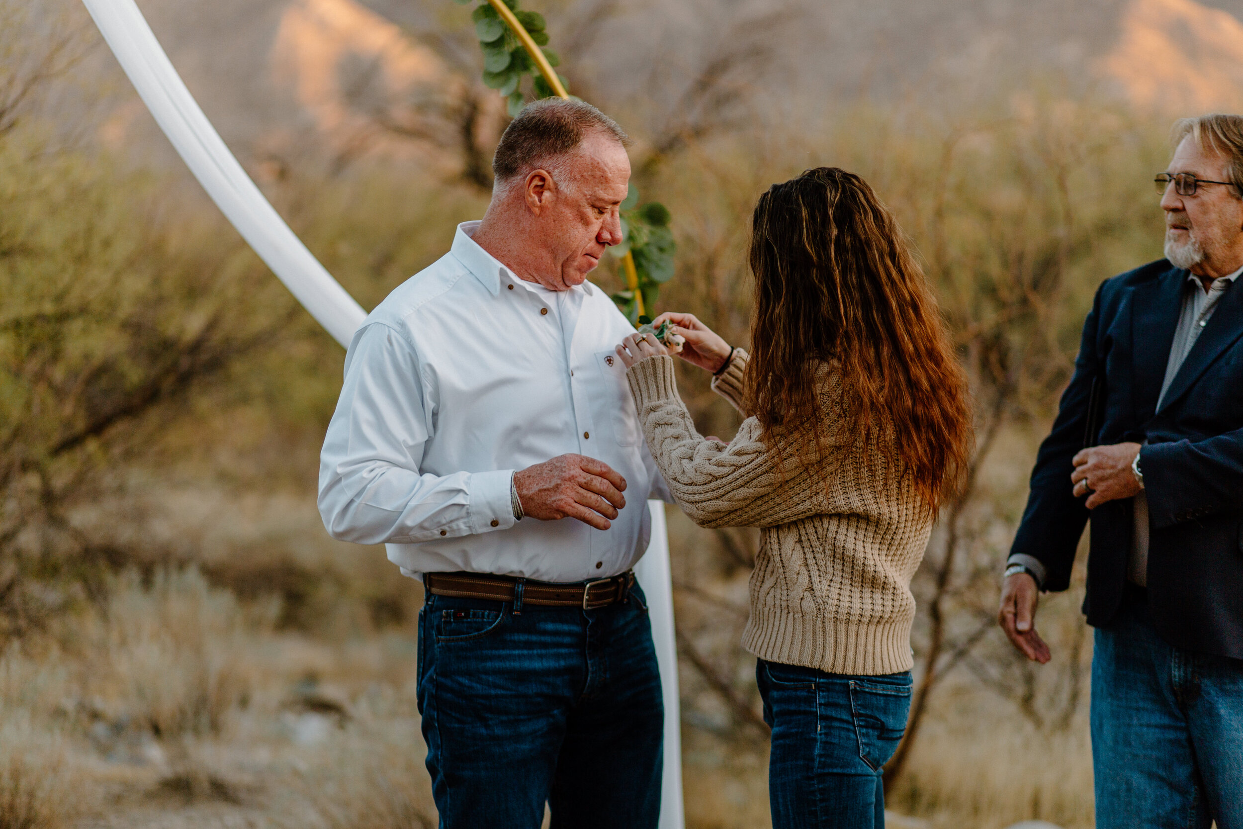  Woman adjusts her dad’s boutinniere after his elopement ceremony in Catalina State Park in Tucson. Tucson elopement photographer, Lucy B. Photography. 