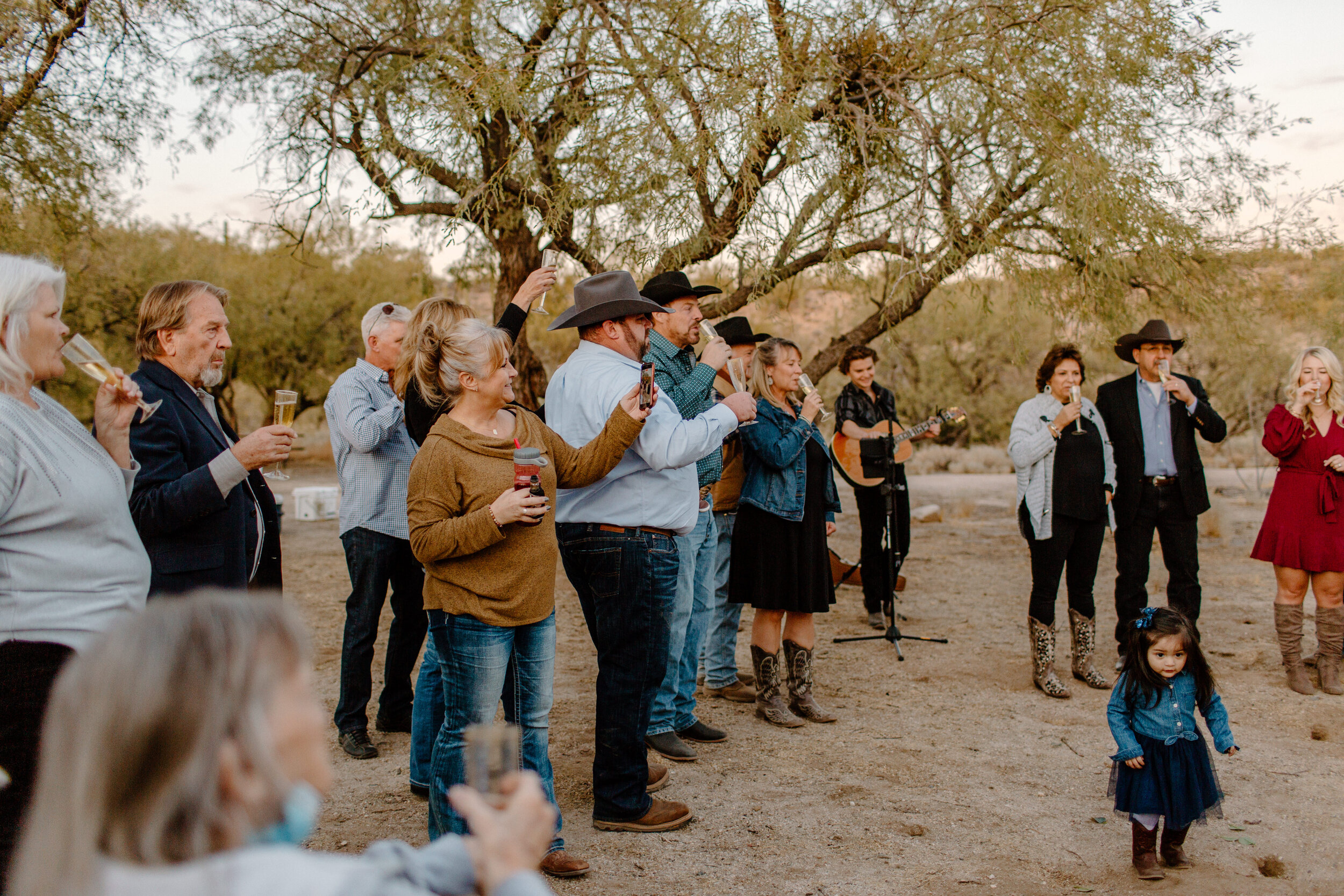  Family and friends raise a glass of champagne to the newly married couple after their elopement ceremony in Catalina State Park in Tucson. Tucson elopement photographer, Lucy B. Photography. 