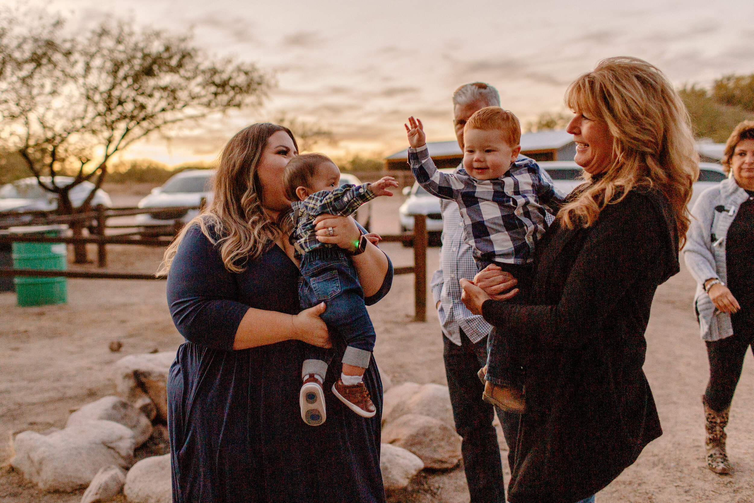  Two women each hold a baby as the two babies wave their hands at each other after an elopement ceremony in Catalina State Park in Tucson. Tucson elopement photographer, Lucy B. Photography. 