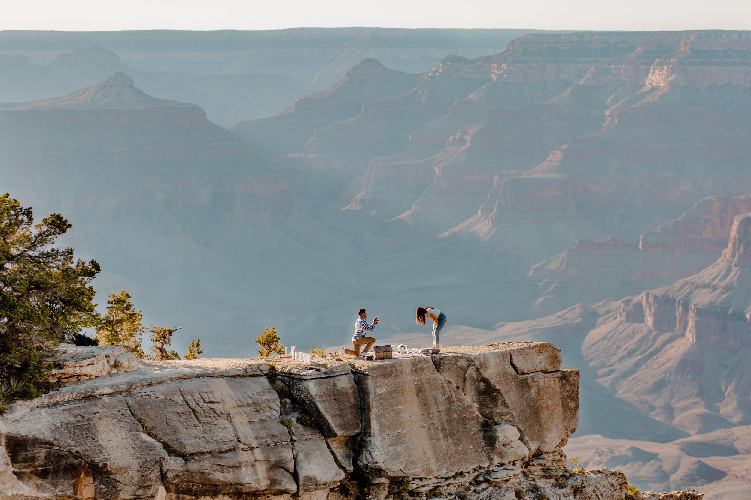  Far away shot of man proposing to his girlfriend on a cliff at the Grand Canyon 