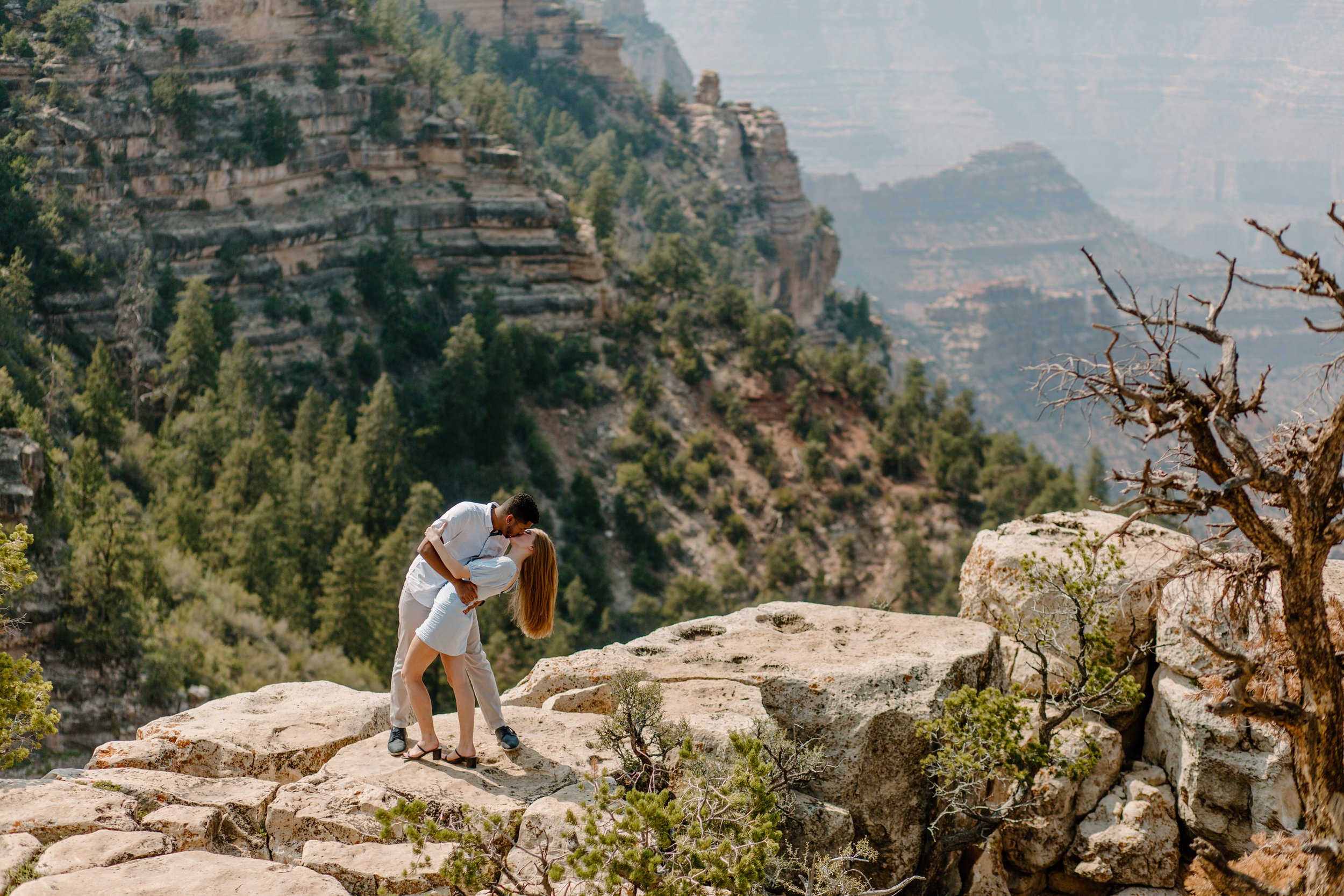  Couple does a dramatic dip kiss pose while standing on a cliff at the Grand Canyon 