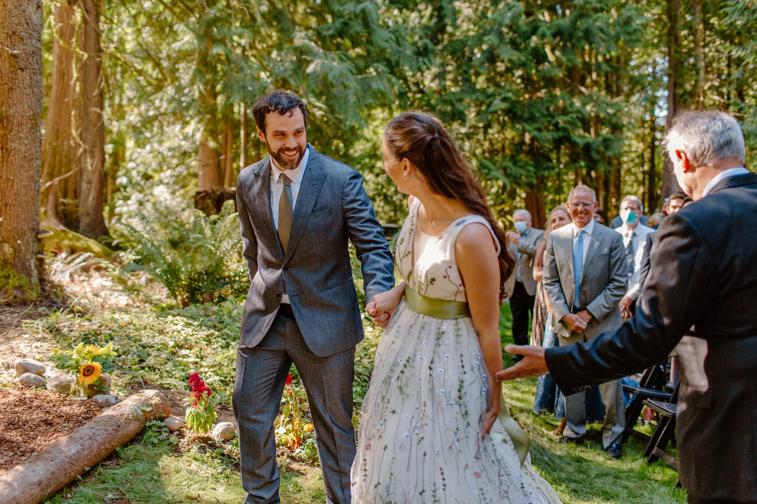  Couple walks happily together to their arch after bride handed off by parents in Seattle Washington 