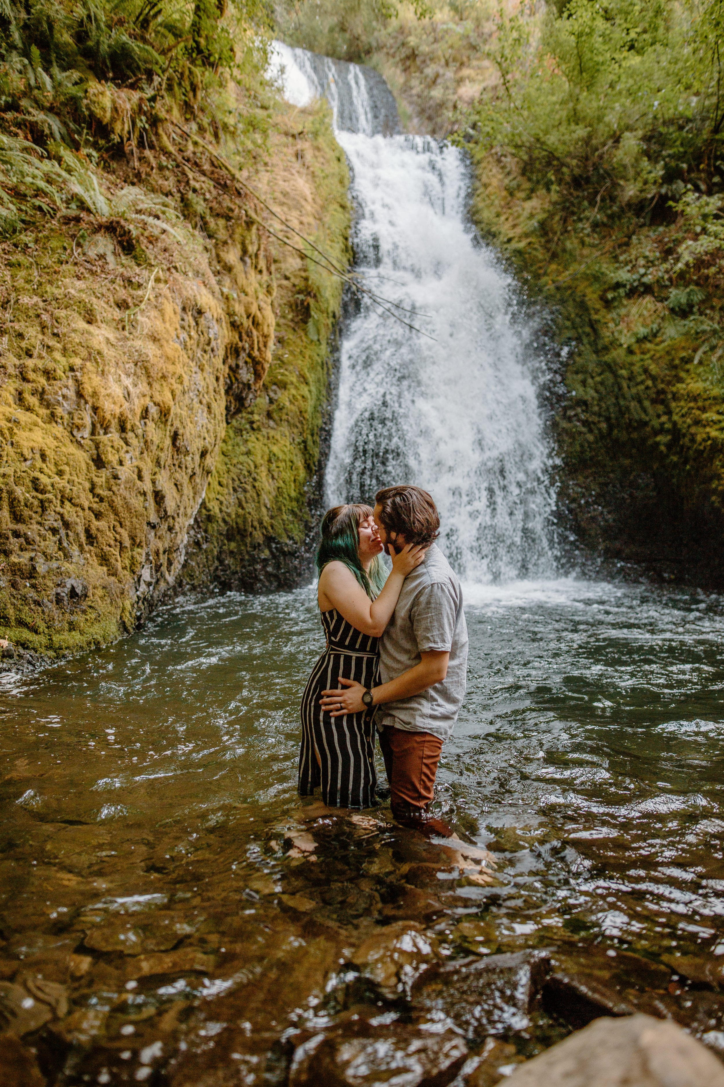  Couple kisses in the water in front of Bridal Veil Falls in the Columbia River Gorge near Portland Oregon 