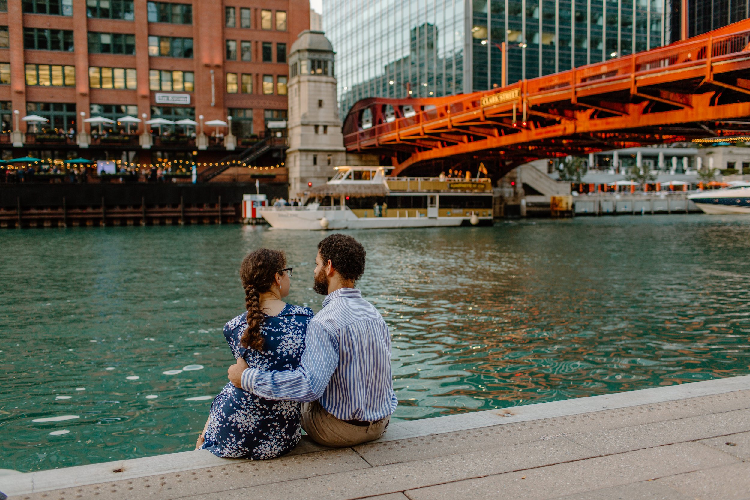  Couple sits and looks at each other by the river on the Chicago Riverwalk 