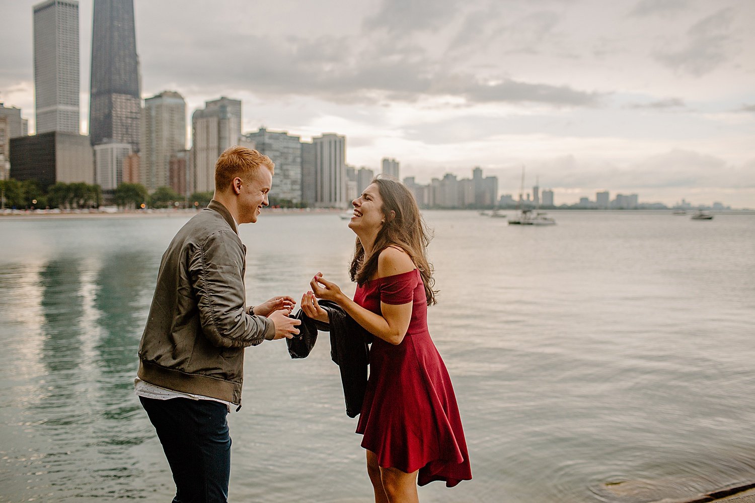  Man and woman excited on water for surprise proposal near Chicago skyline 
