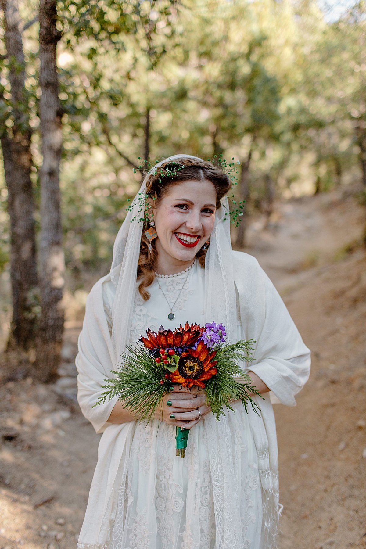  bridal portrait of woman holding red wedding bouquet and wearing a long veil by Lucy Bouman 