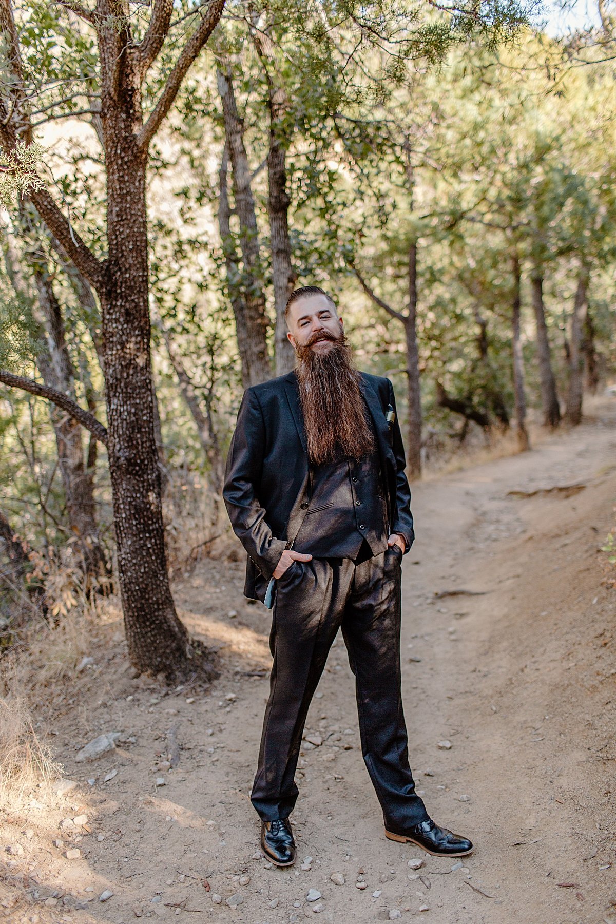  grooms portrait wearing a navy blue suit and a long red beard  